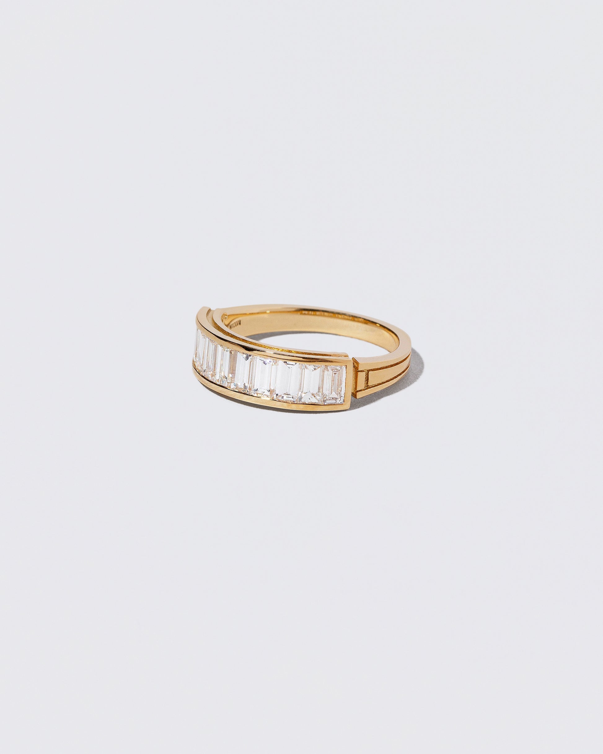 View from the side of the Gold Arcade Ring on light color background.