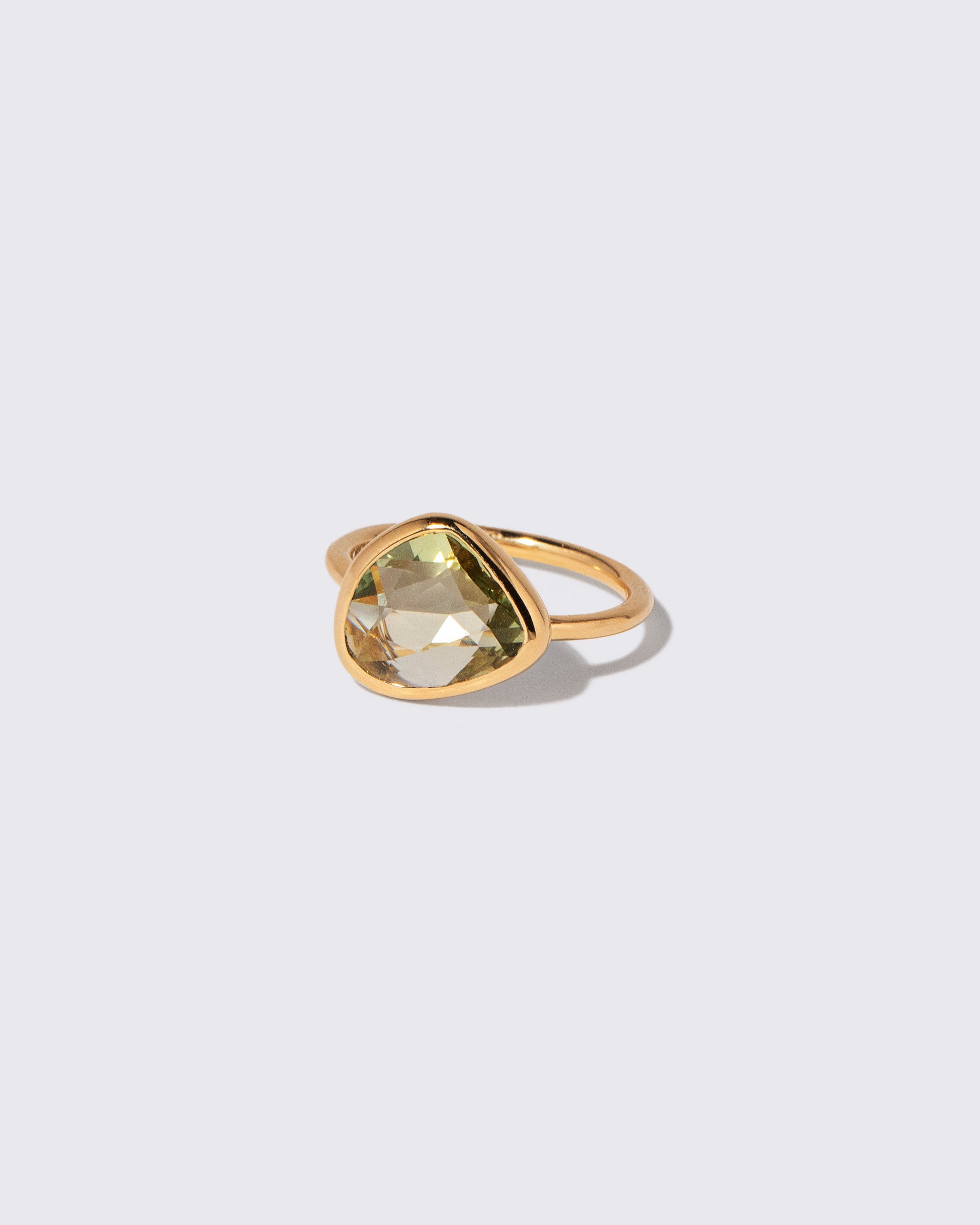 View from the side of the Green Sapphire Gusher Ring on light color background.