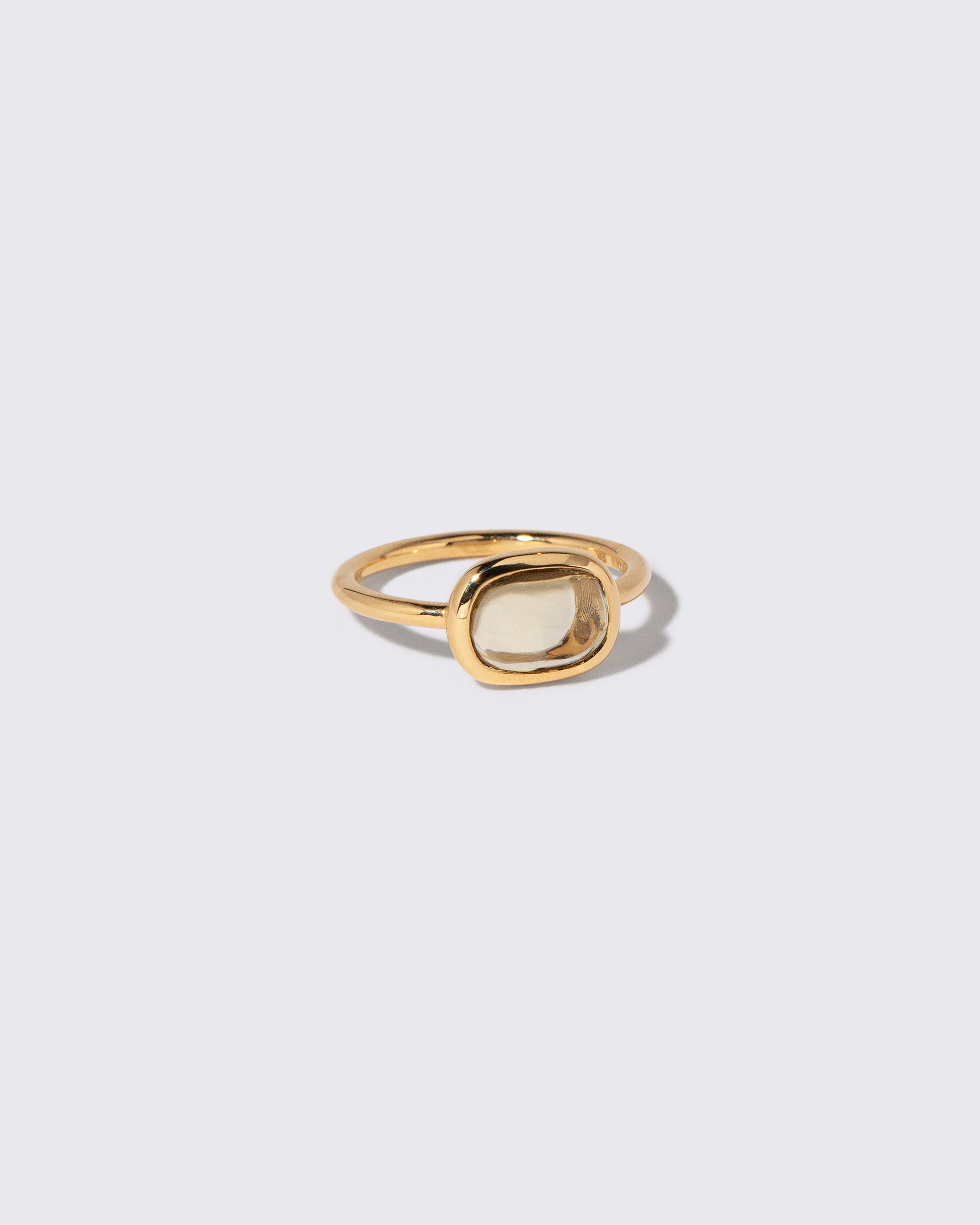 View from the side of the Green Sapphire Gusher Ring on light color background.