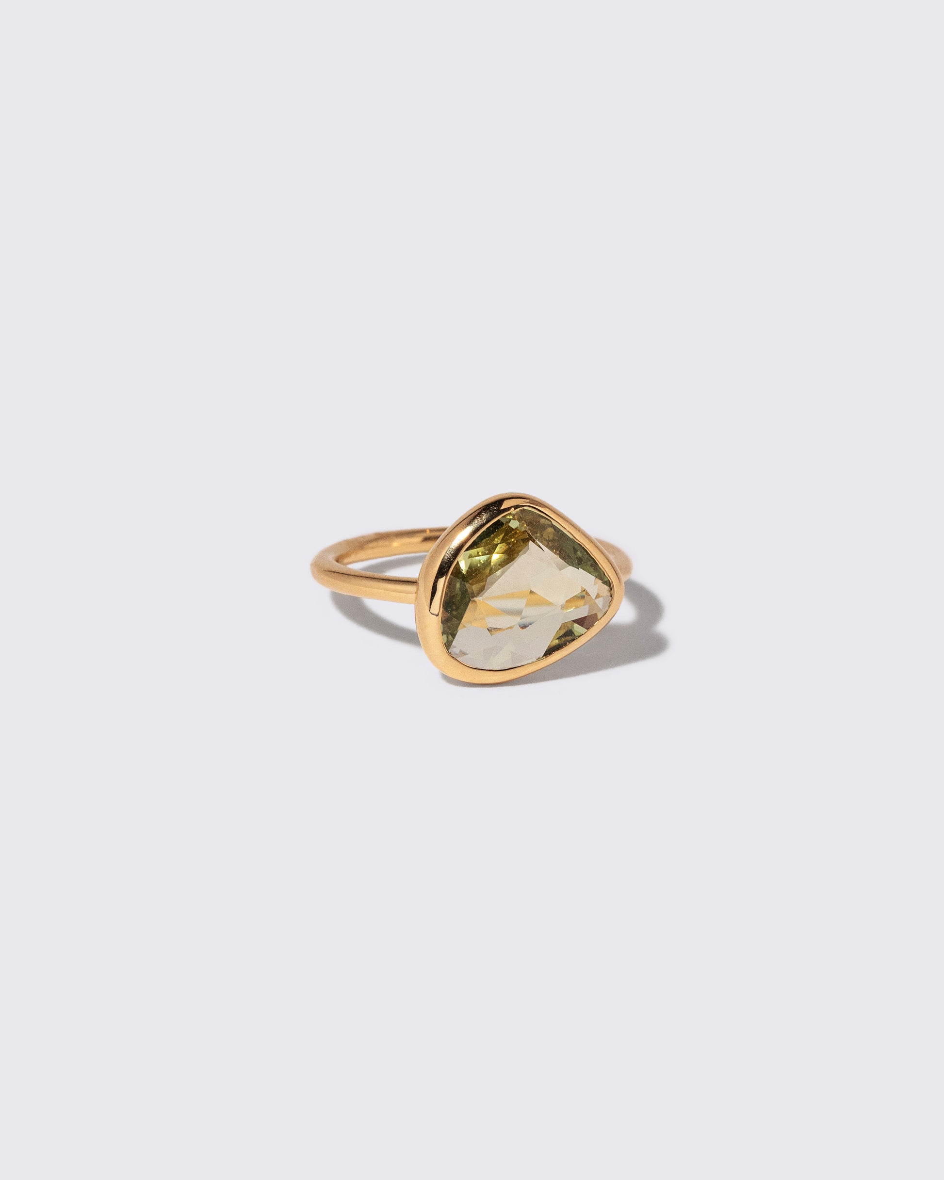 View from the side of the Green Sapphire Gusher Ring on light color background.