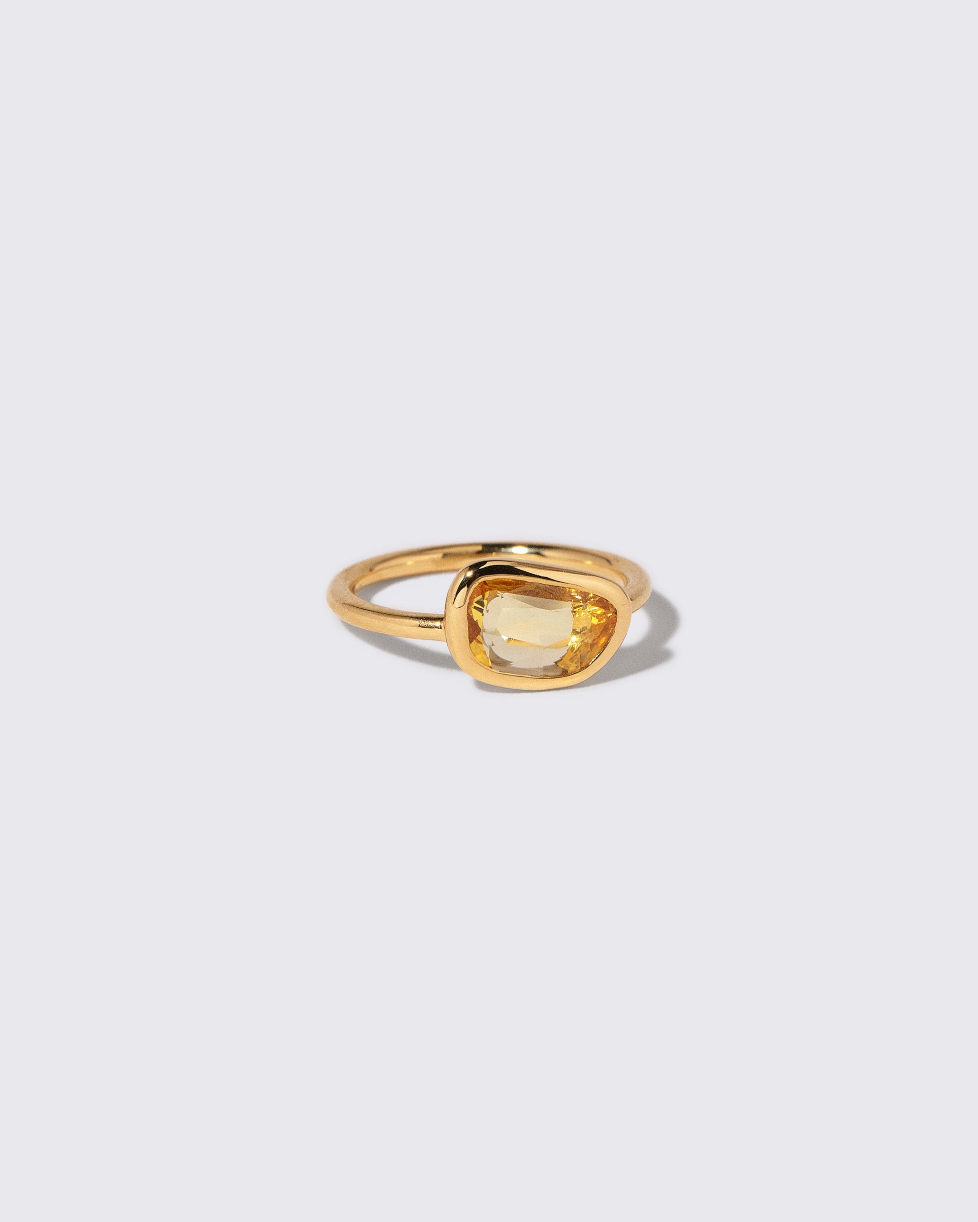 View from the side of the Yellow Sapphire Gusher Ring on light color background.