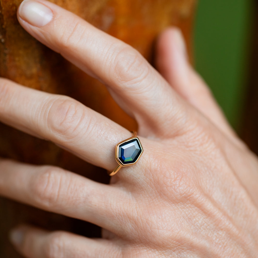 product_details::Teal Blue Sapphire Gusher Ring on model.