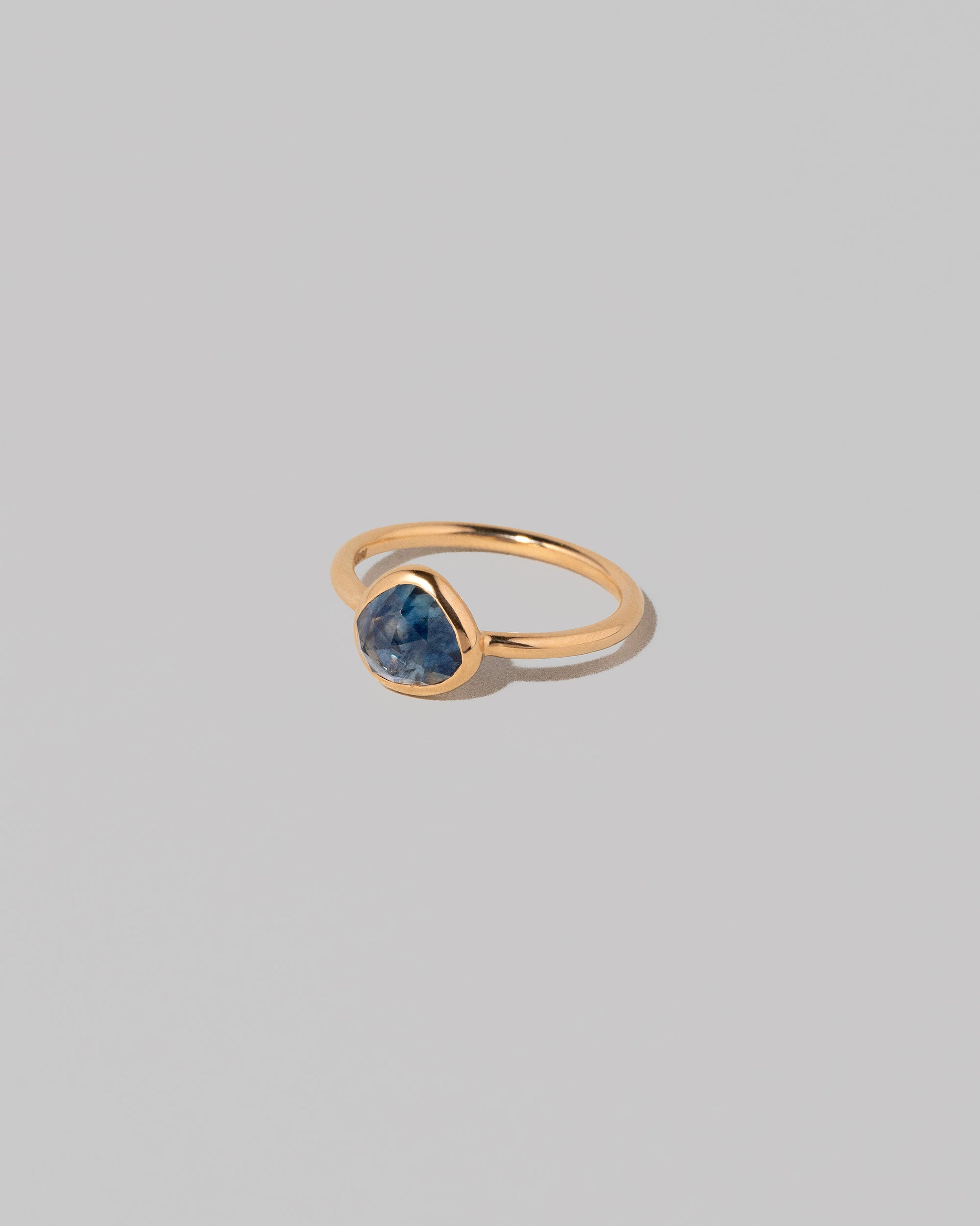 View from the side of the Gusher Blue Sapphire Ring 005 on light color background.