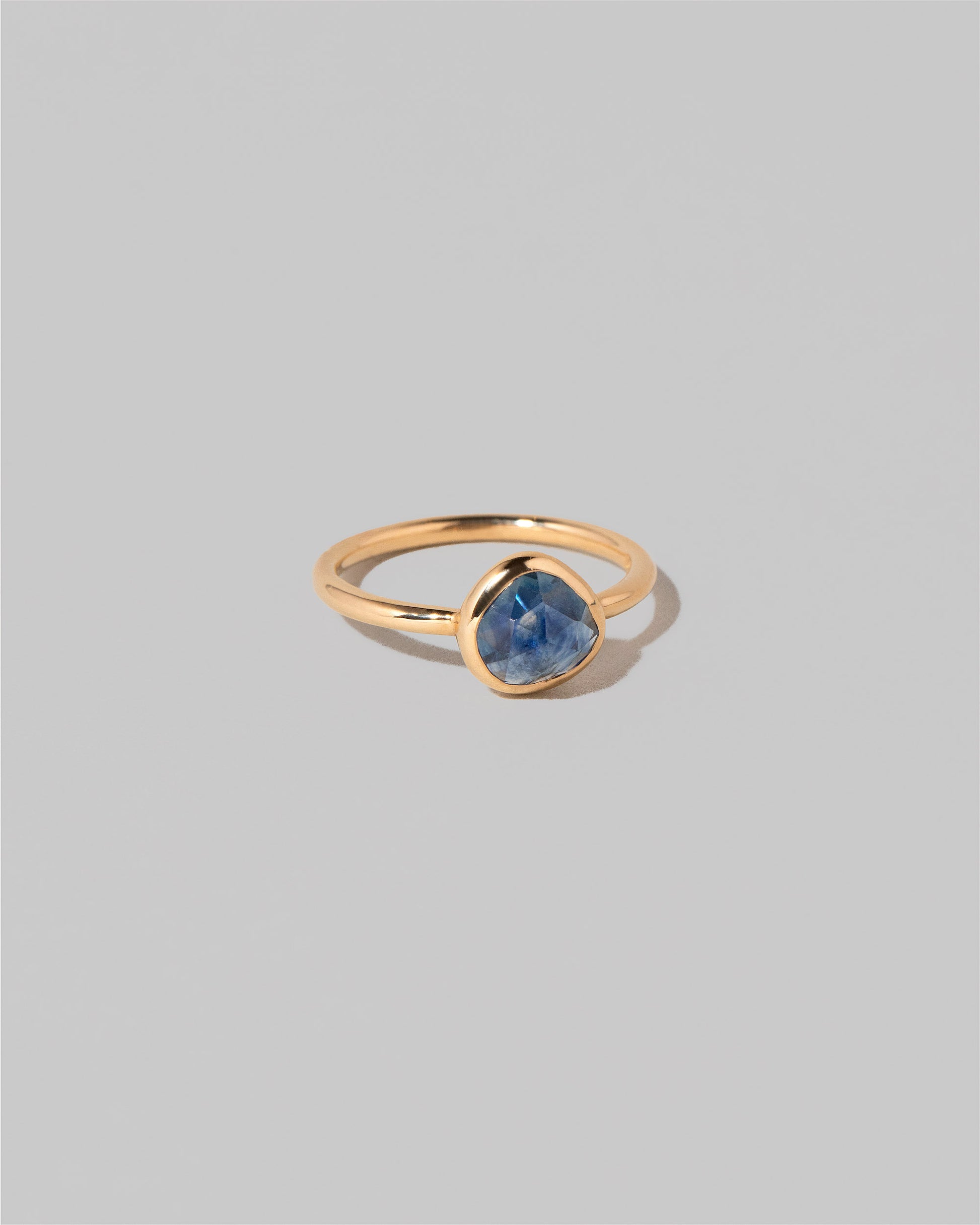View from the side of the Gusher Blue Sapphire Ring 005 on light color background.
