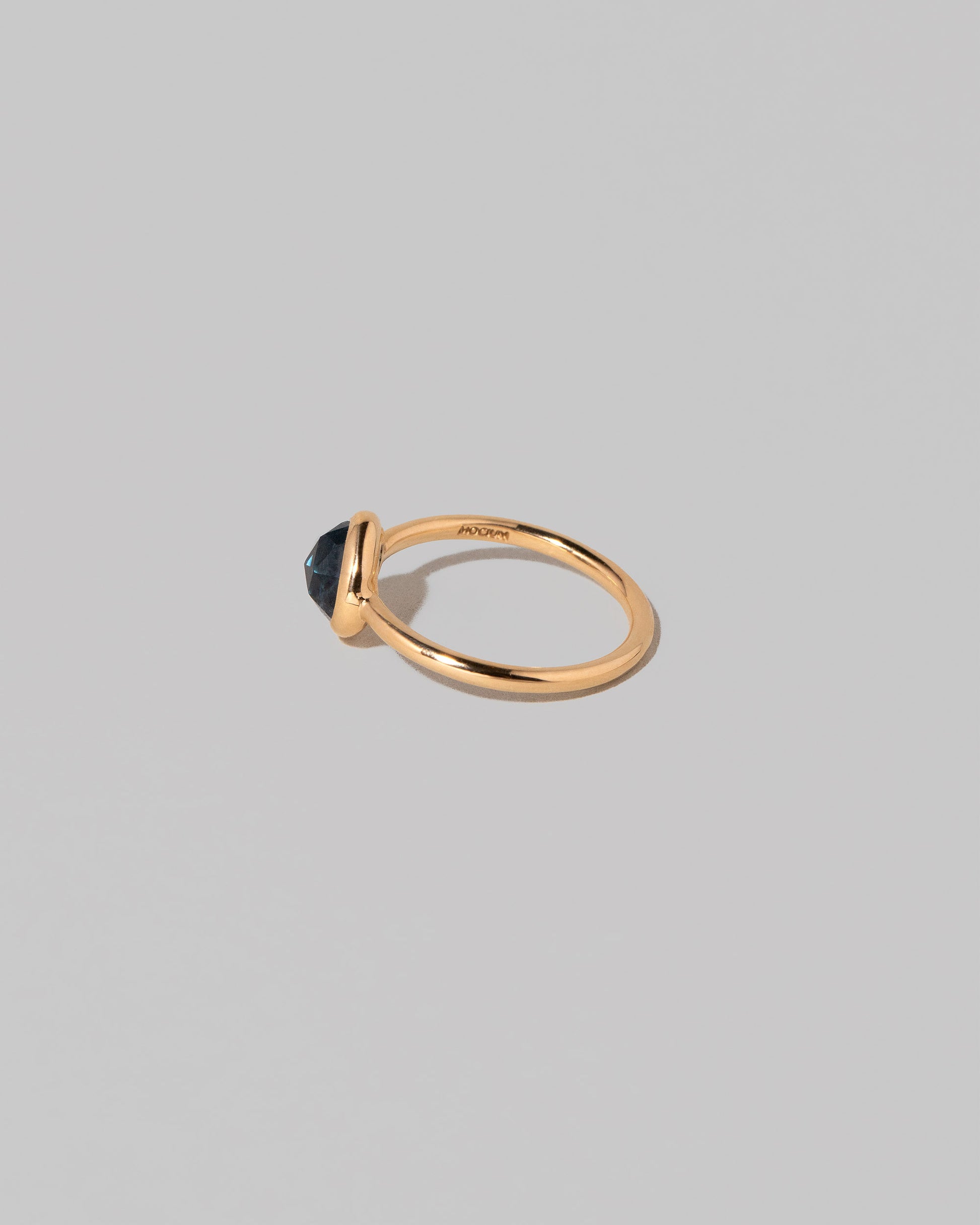 View from the back of the Gusher Blue Sapphire Ring 005 on light color background.
