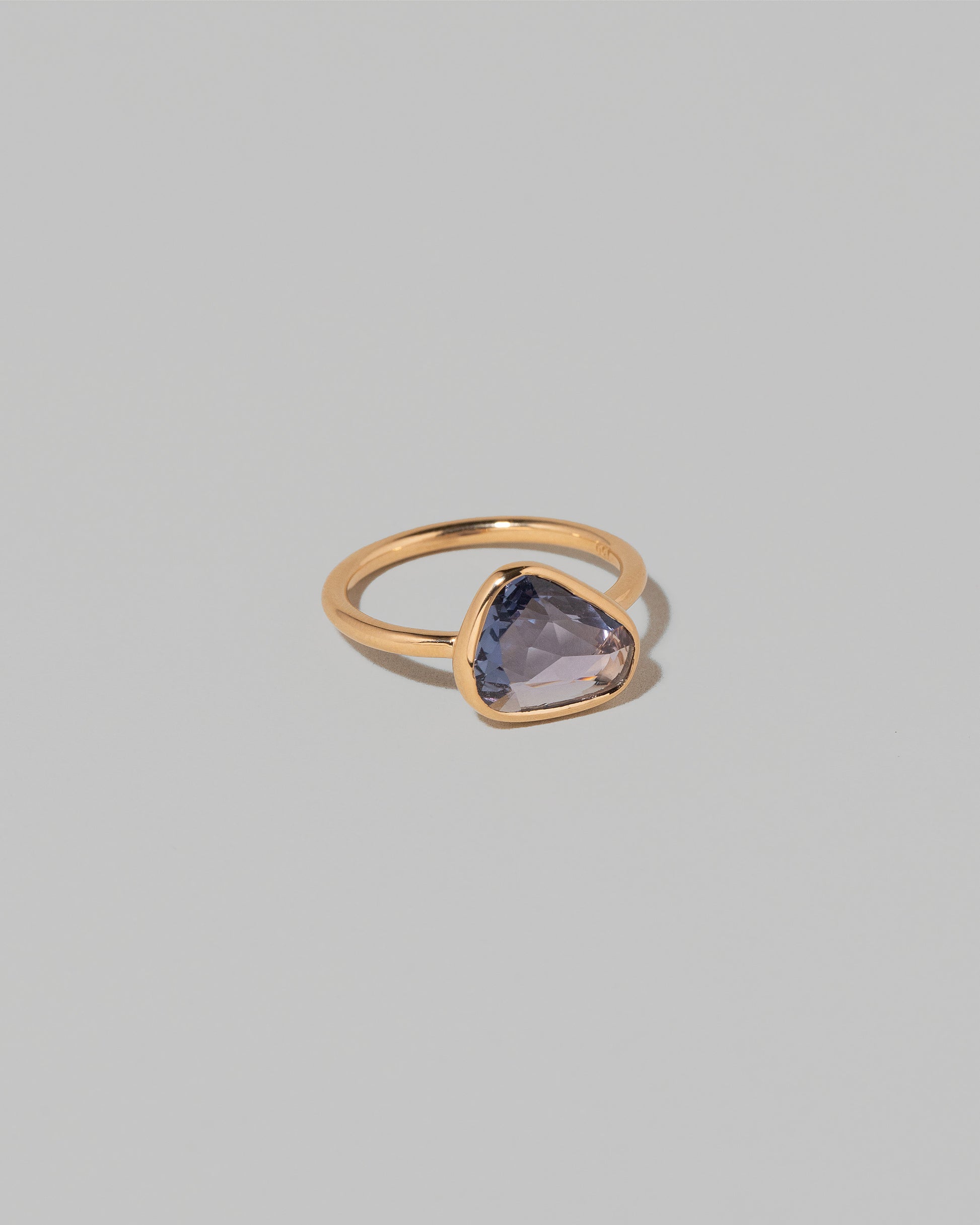 View from the side of the Gusher Purple Sapphire Ring 001 on light color background.