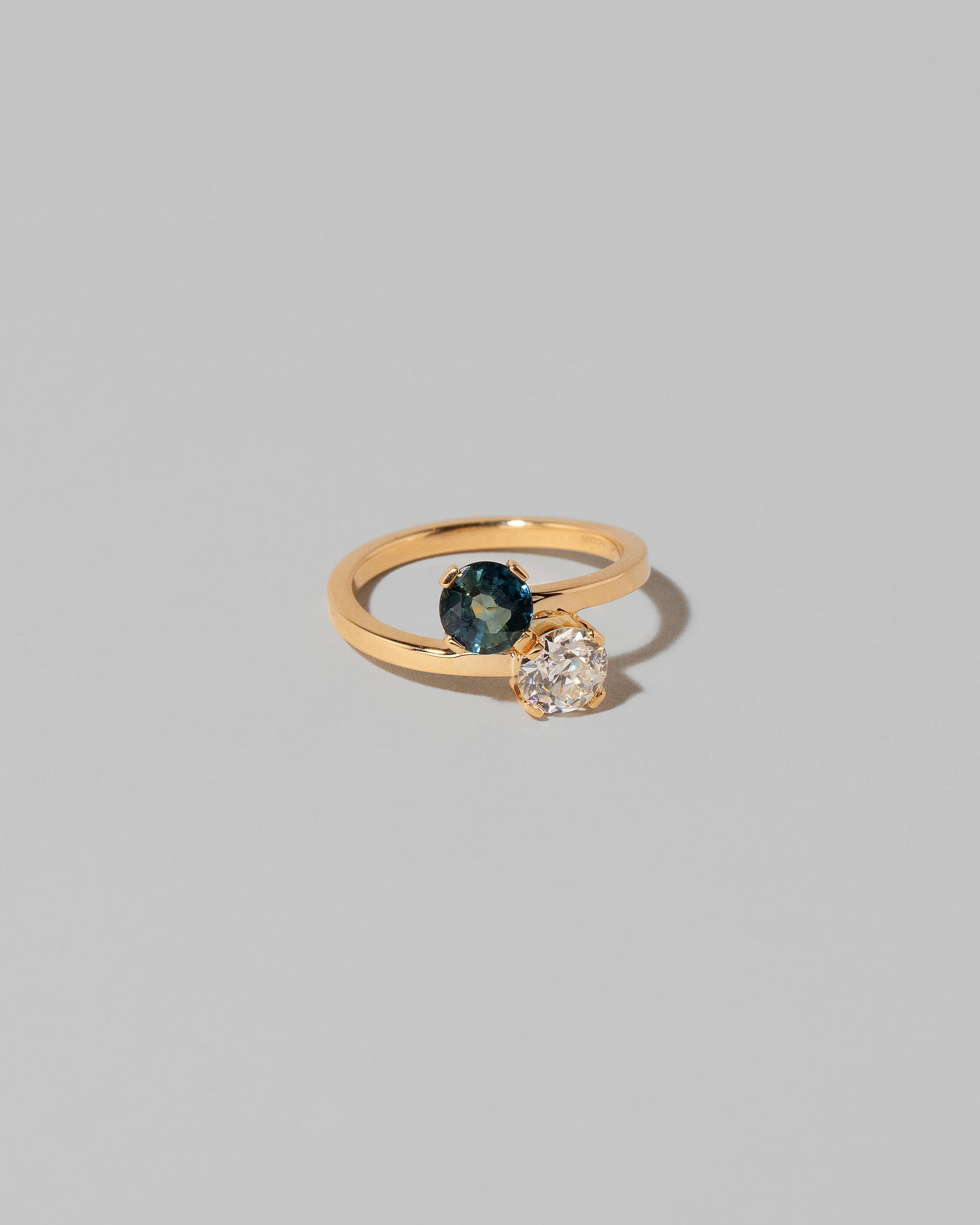 View from the side of the Sapphire & Diamond Union Ring on light color background.