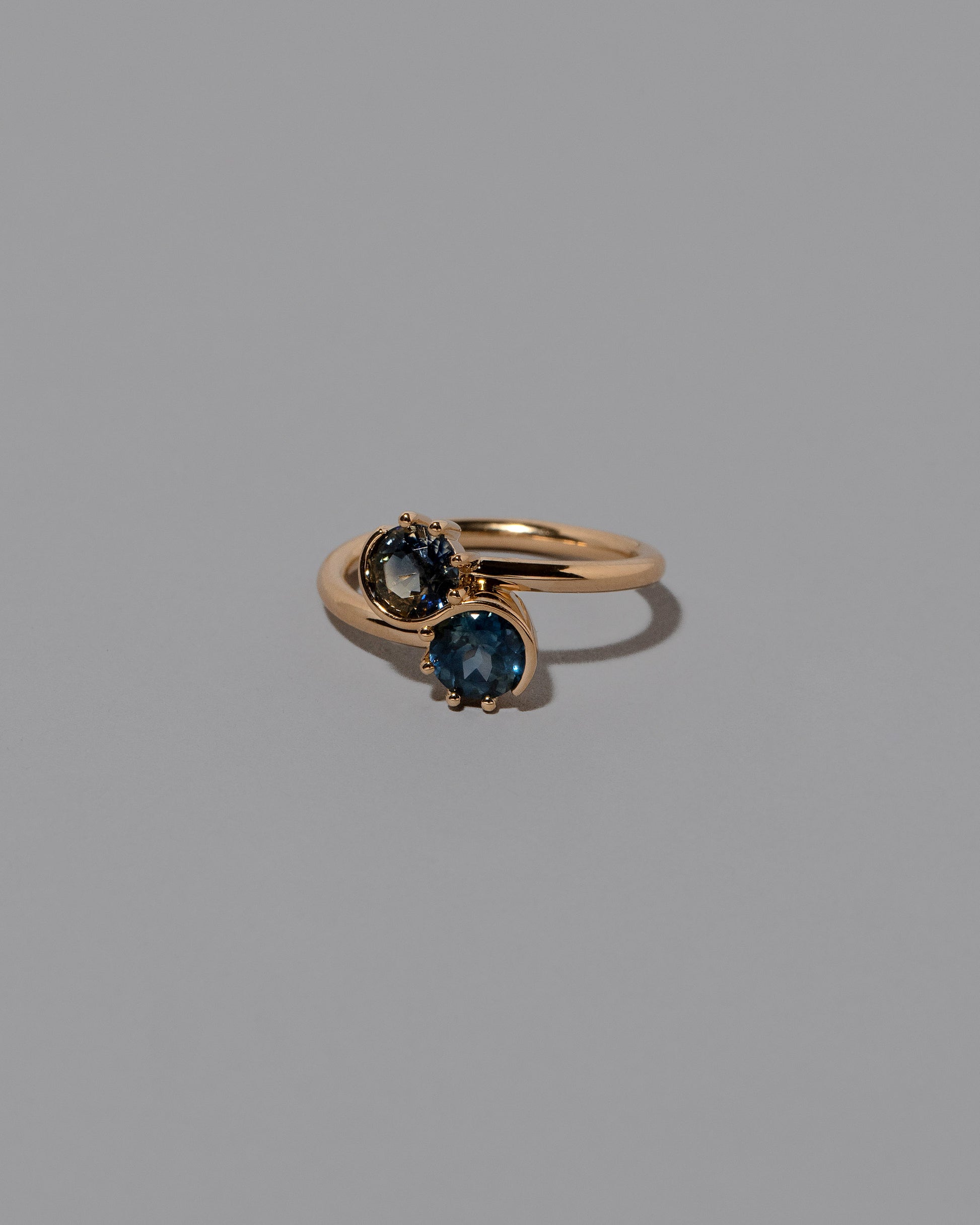 View from the side of the Sapphire Sun & Moon Union Ring on light color background.