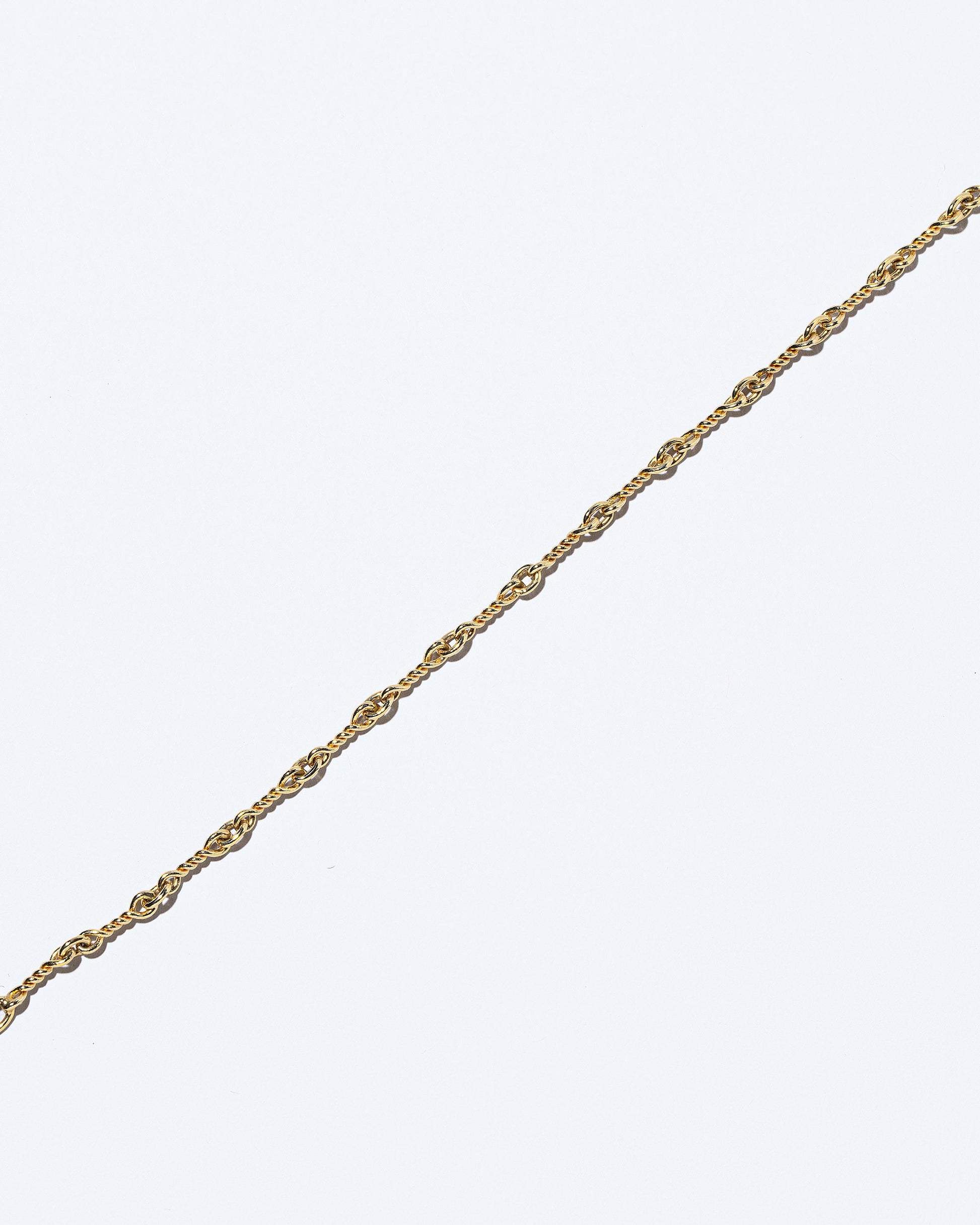 Closeup details of the Twisted Chain Necklace on light color background.