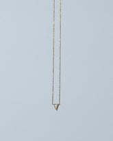 Gold White Opal Triangle Necklace on light color background.