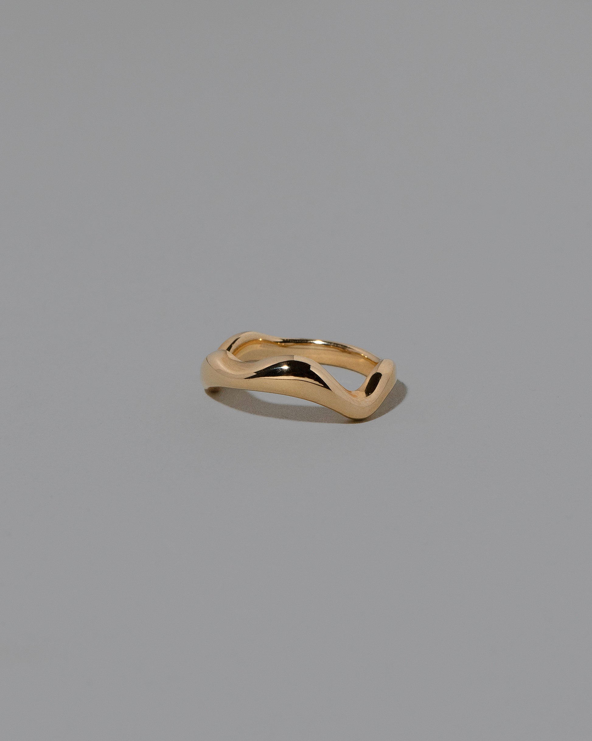 View from the side of the Gold Wide Fluctuating Band on light color background.
