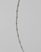 Closeup details of the CRZM Sterling Silver Double Helix Chain Necklace on light color background.