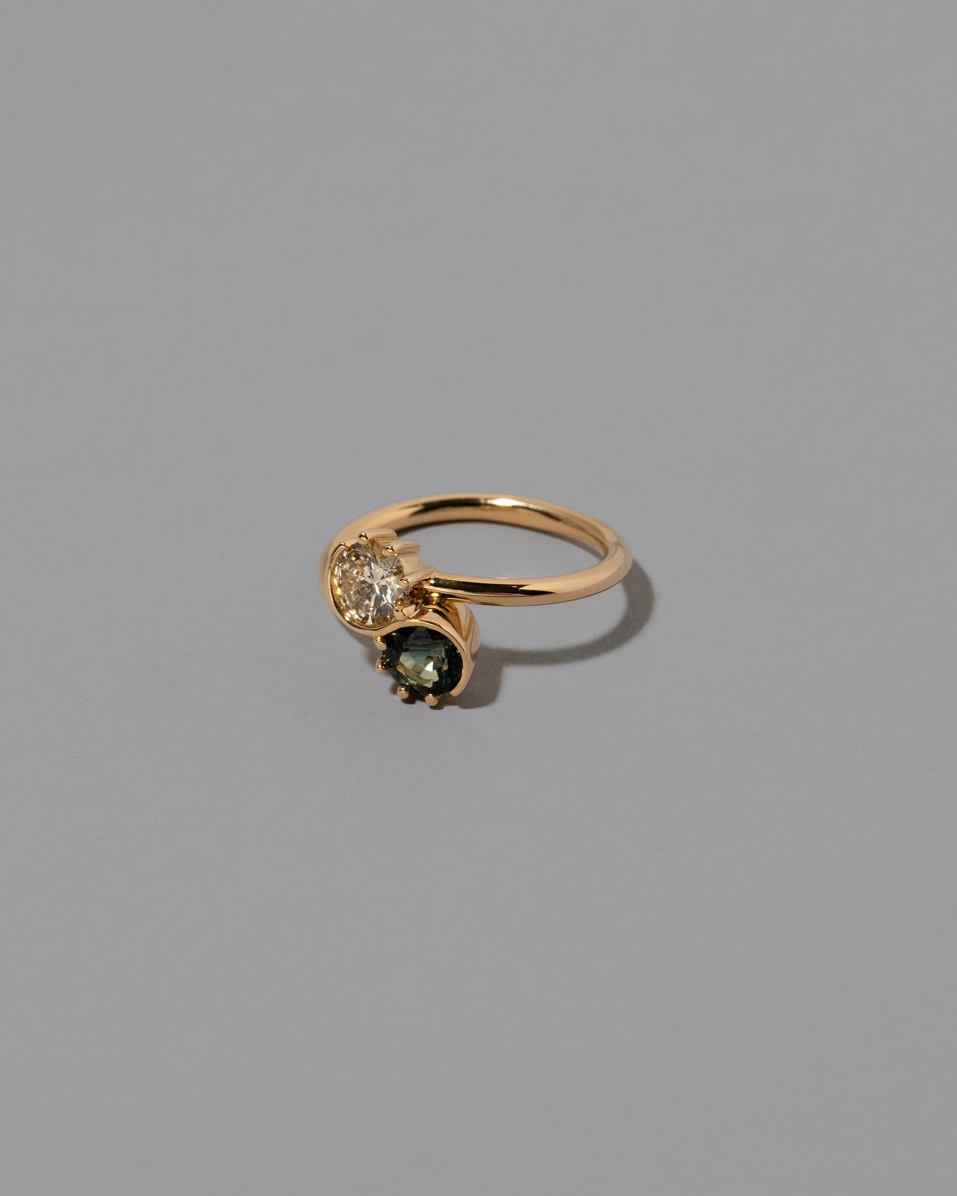View from the side of the Sapphire & Champagne Diamond Sun & Moon Union Ring on light color background.