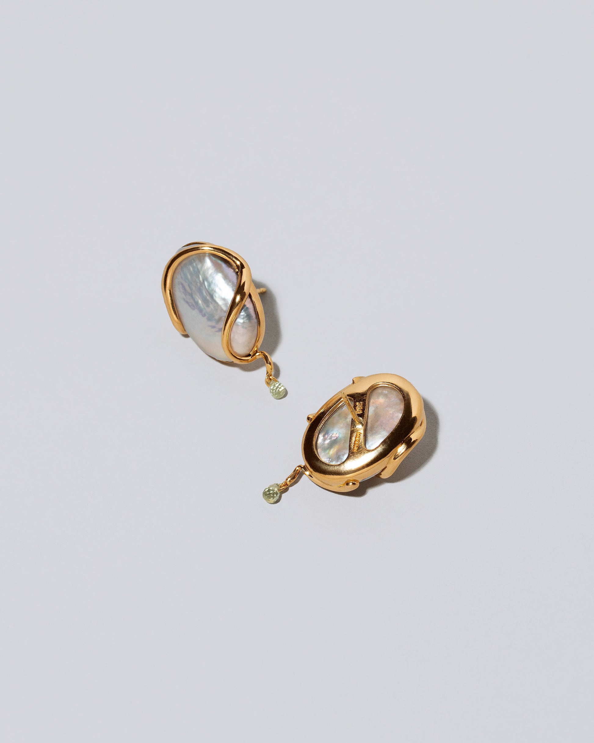 View from the back of the Weaver Earrings on light color background.
