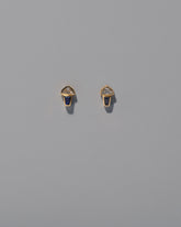 Vela Earrings on light color background.