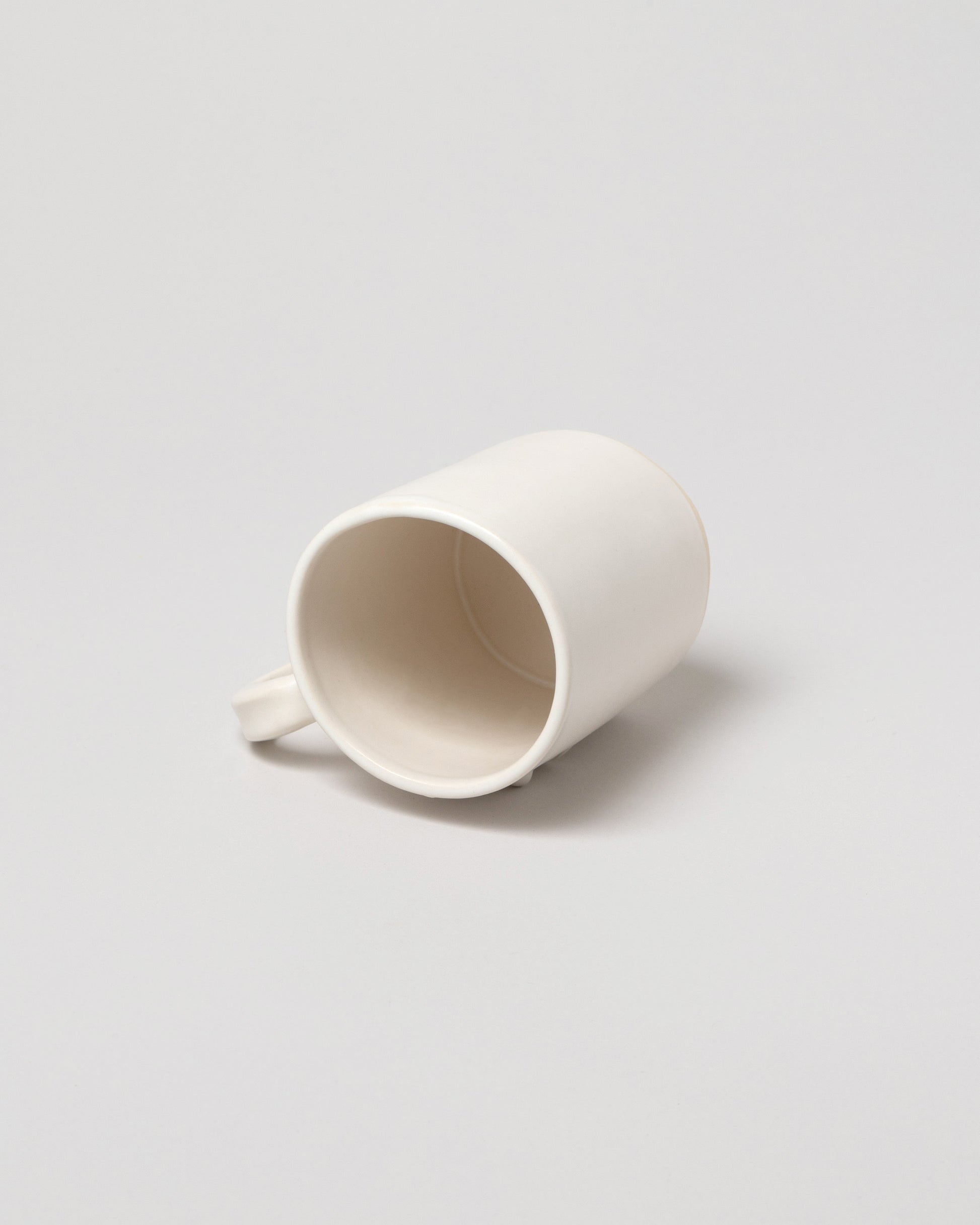 Detail view of Rami Kim Face Mug on light color background.