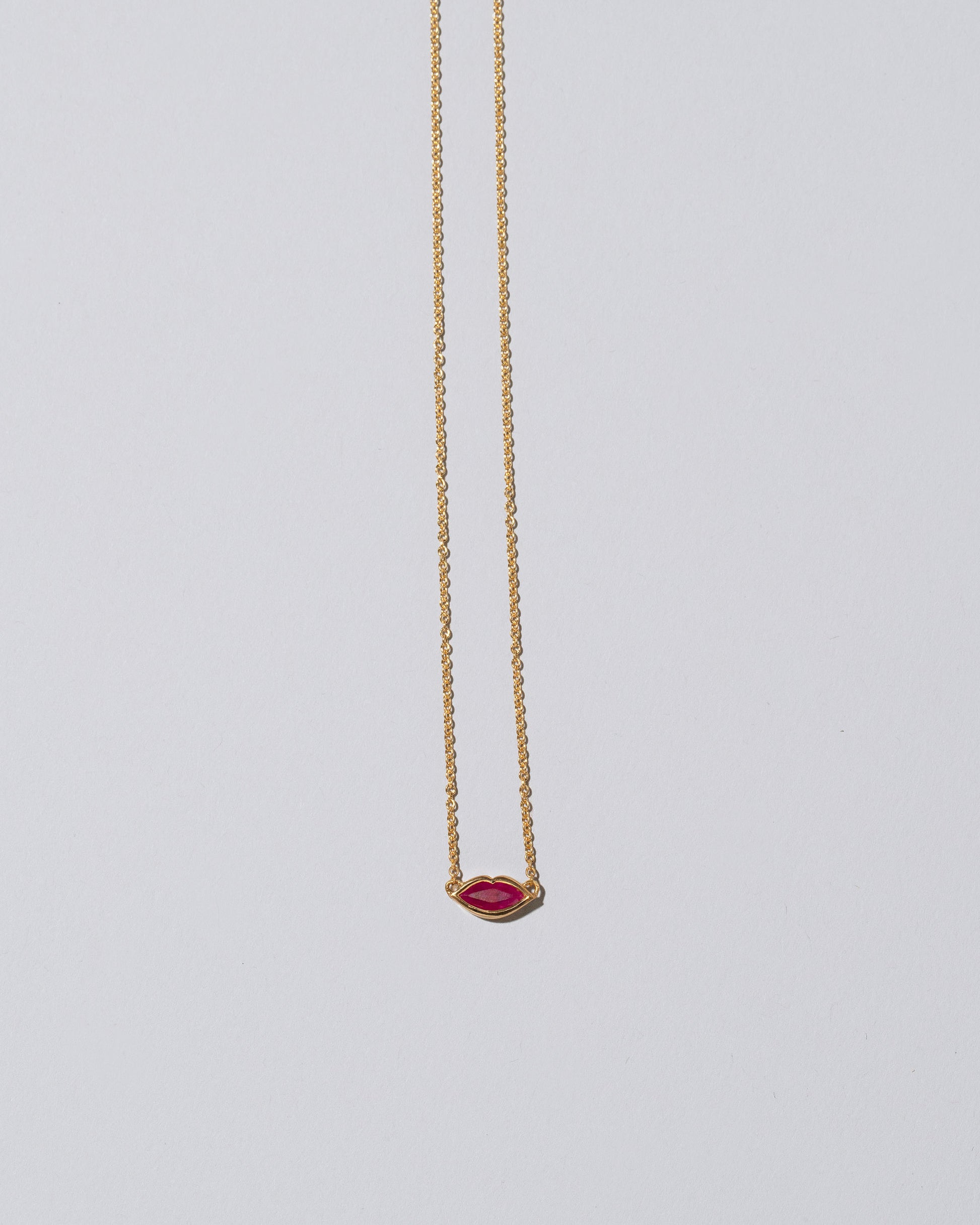 Red Big Kiss Necklace on light color background.