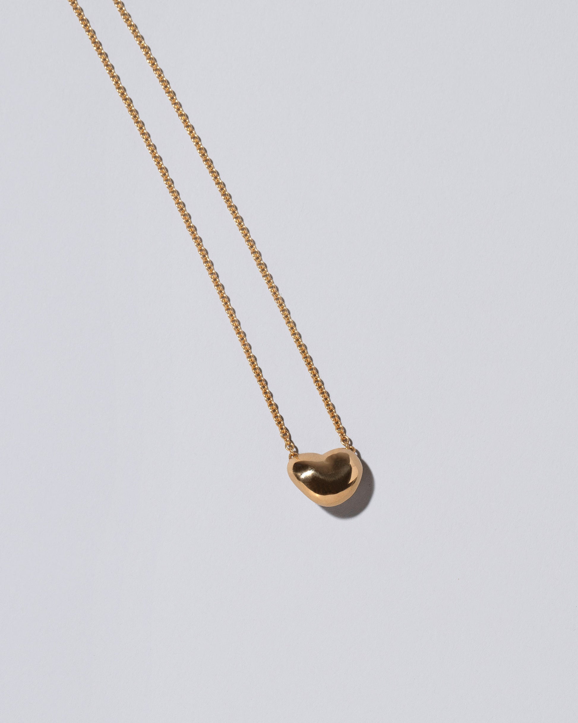 View from the back of the Lunar Heart Necklace on light color background.