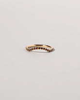 Gold Garnet Pavé Mini Curve Band on light color background.