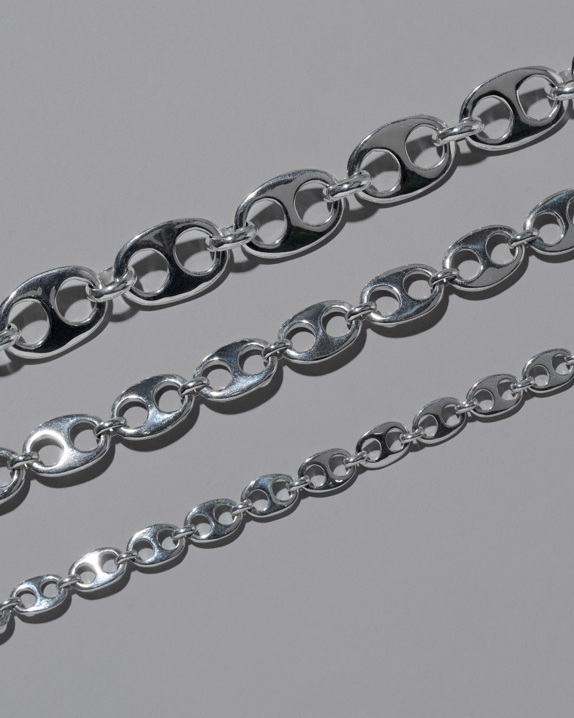 Closeup details of the CRZM Sterling Silver Yuba Mini Bracelet, Sterling Silver Yuba Medium Bracelet, and Sterling Silver Yuba Bracelet on light color background.