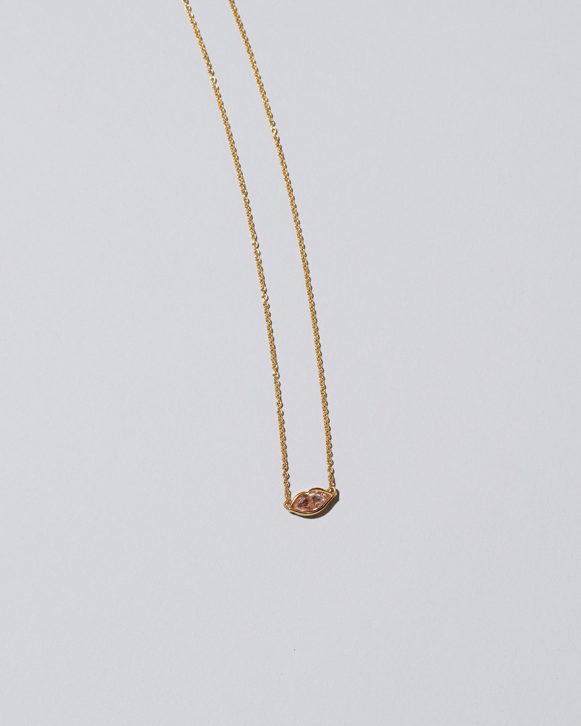 Closeup detail of the Light Pink Big Kiss Necklace on light color background.