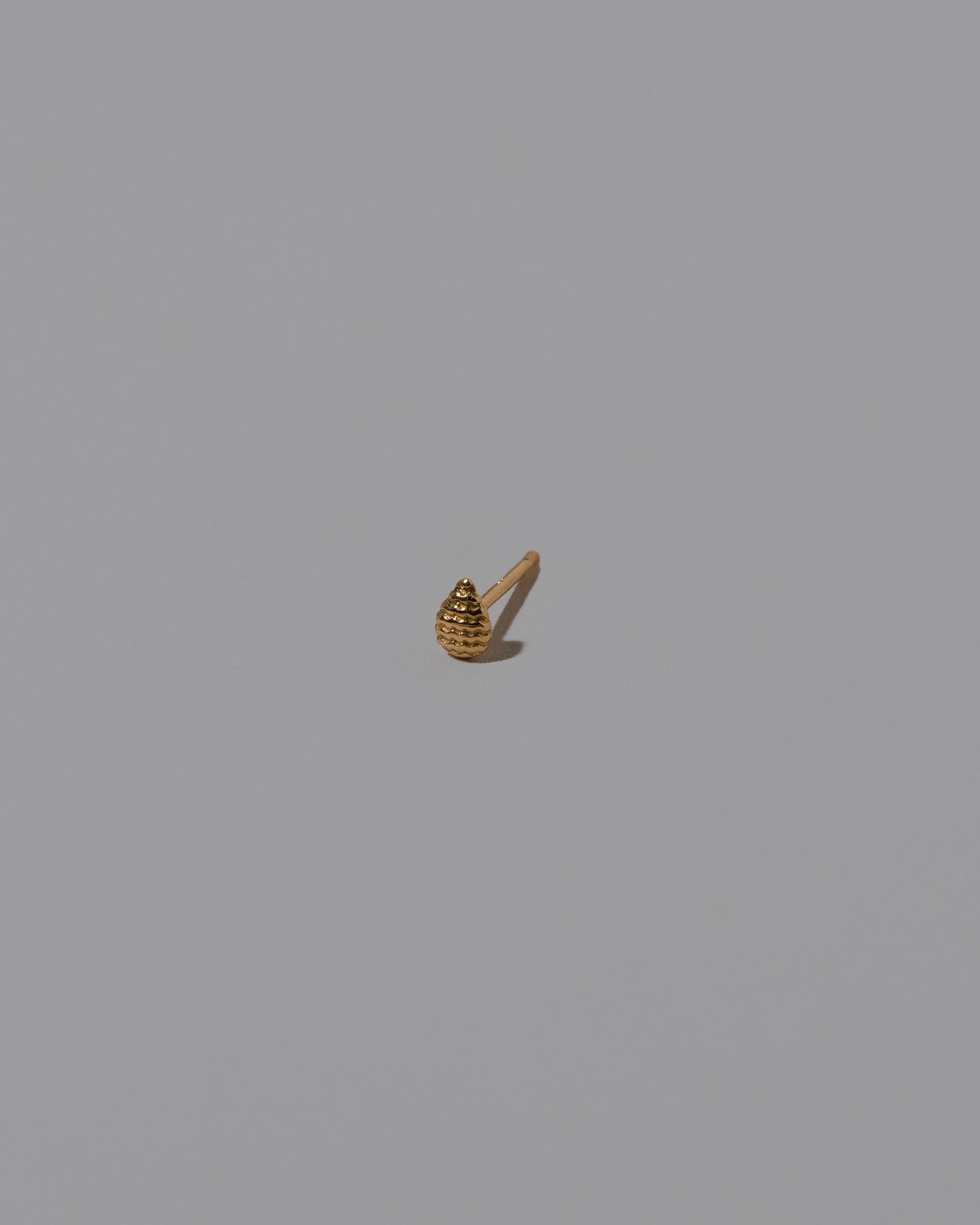 Tear Stud Earring Single on light color background.