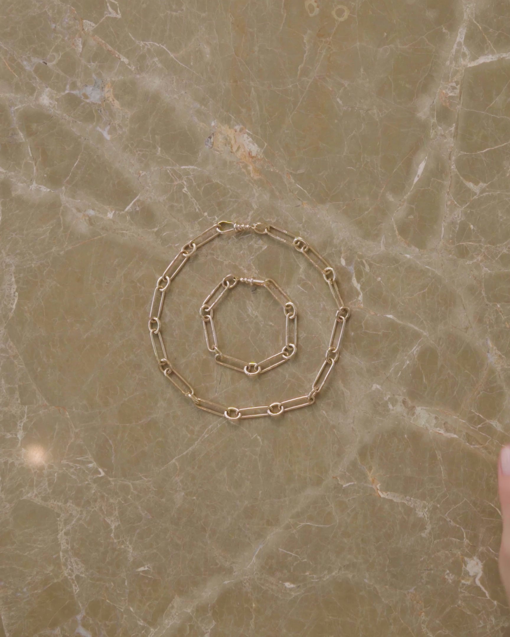 How to style and transform the Link Necklace and Link Bracelet, either by using their included Openable Link and Coiled Swivel Charm Holder clasps to clip them into one continuous chain, using their Coiled Swivel Charm Holder to showcase charms and pendants like the Fried Egg Pendant or introducing a pendant along the line of the chain by clipping in the Sapphire Gusher Openable Link.