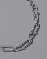 Closeup details of the CRZM Sterling Silver Canyon Necklace on light color background.