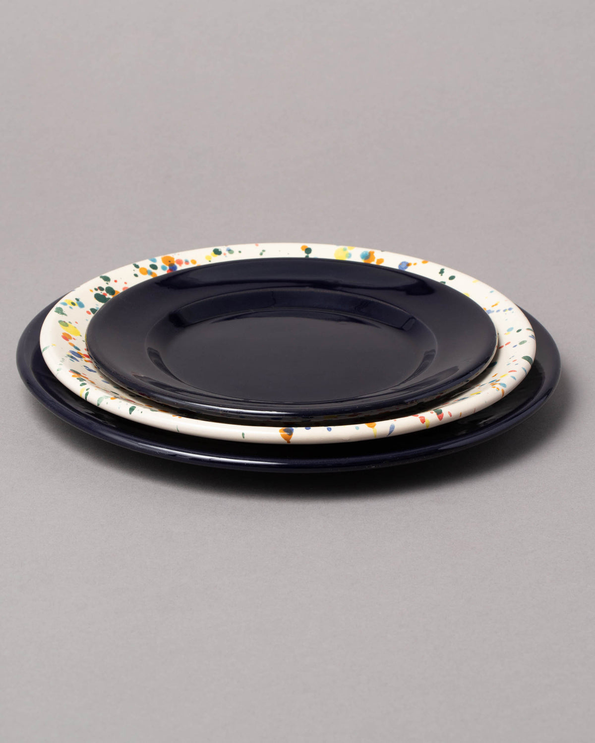 Group of La Ceramica Vincenzo Del Monaco Colored Drops, Caramel Yellow and Midnight Large Dishes on light color background.