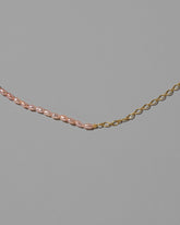 Closeup details of the Half Oval Chain & Peony Seed Pearl Necklace on light color background.