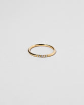 Gold Five Stone Blue Sapphire Dot Band on light color background.