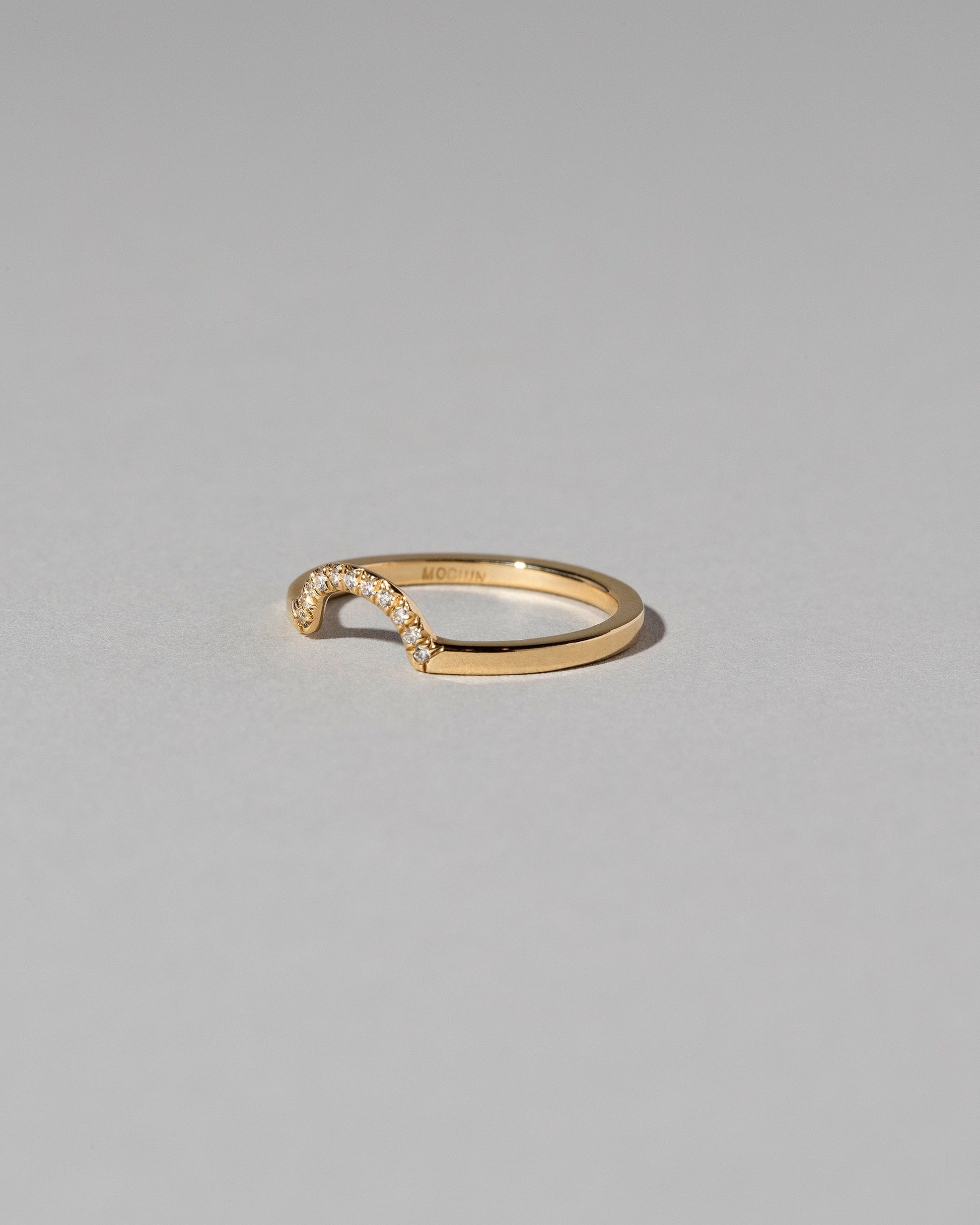 View from the side of the Gold Pavé Mini Half Hoop Band on light color background.