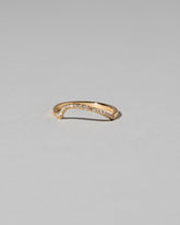 Gold Pavé White Diamond Left Slump Band on light color background.