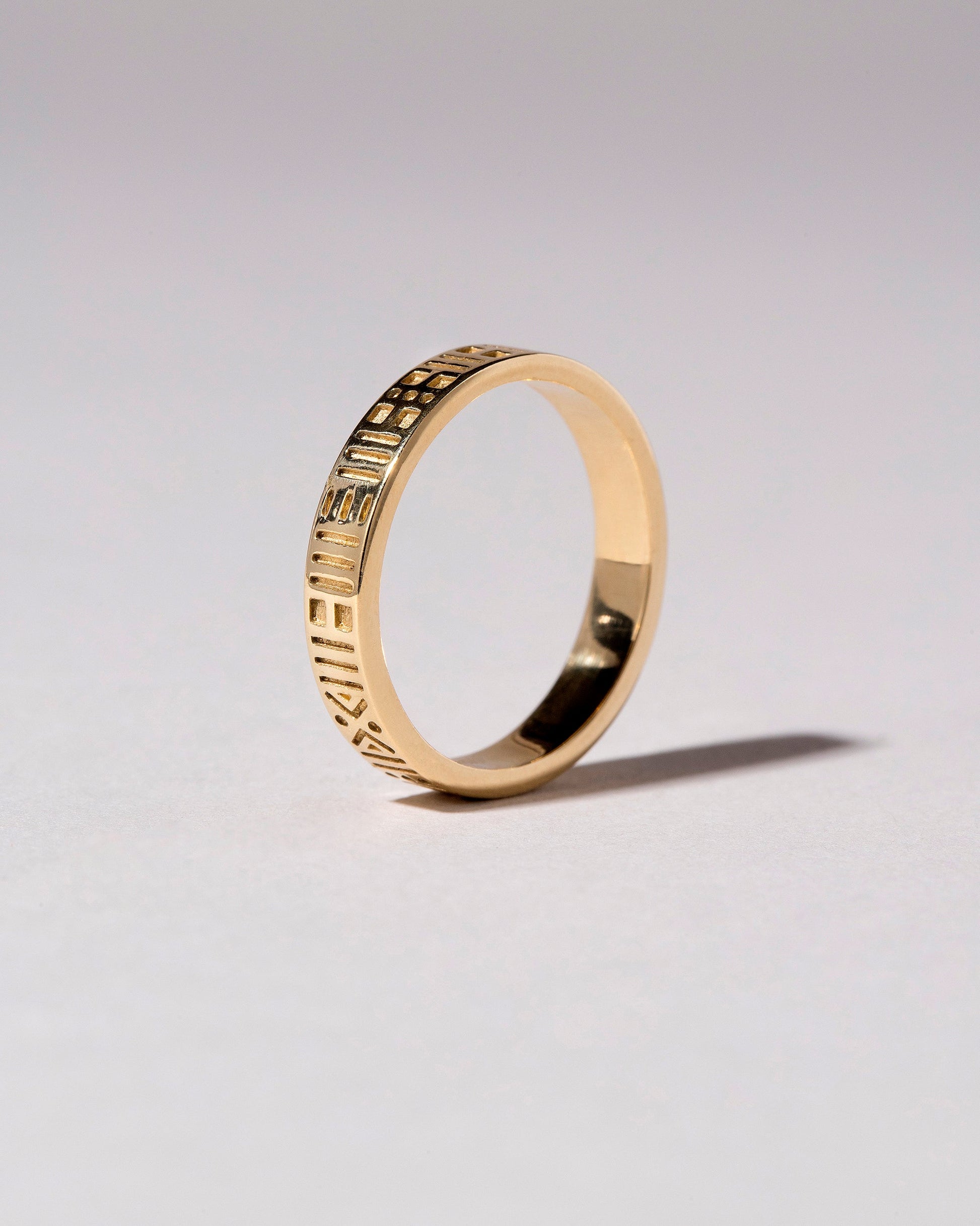 Gold Infinity Etched Band on light color background.