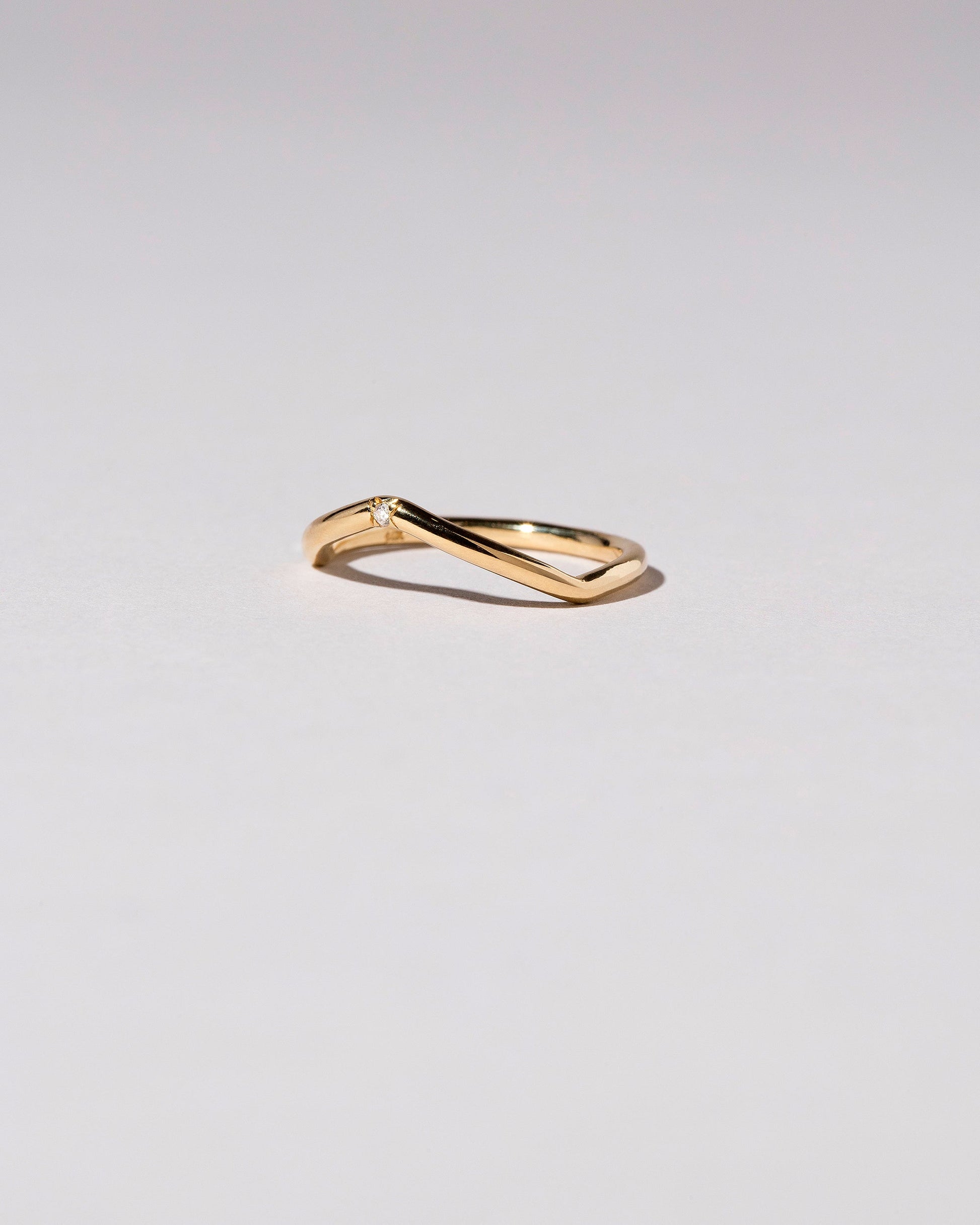 Gold Single Stone White Diamond Low Peak Band on light color background.