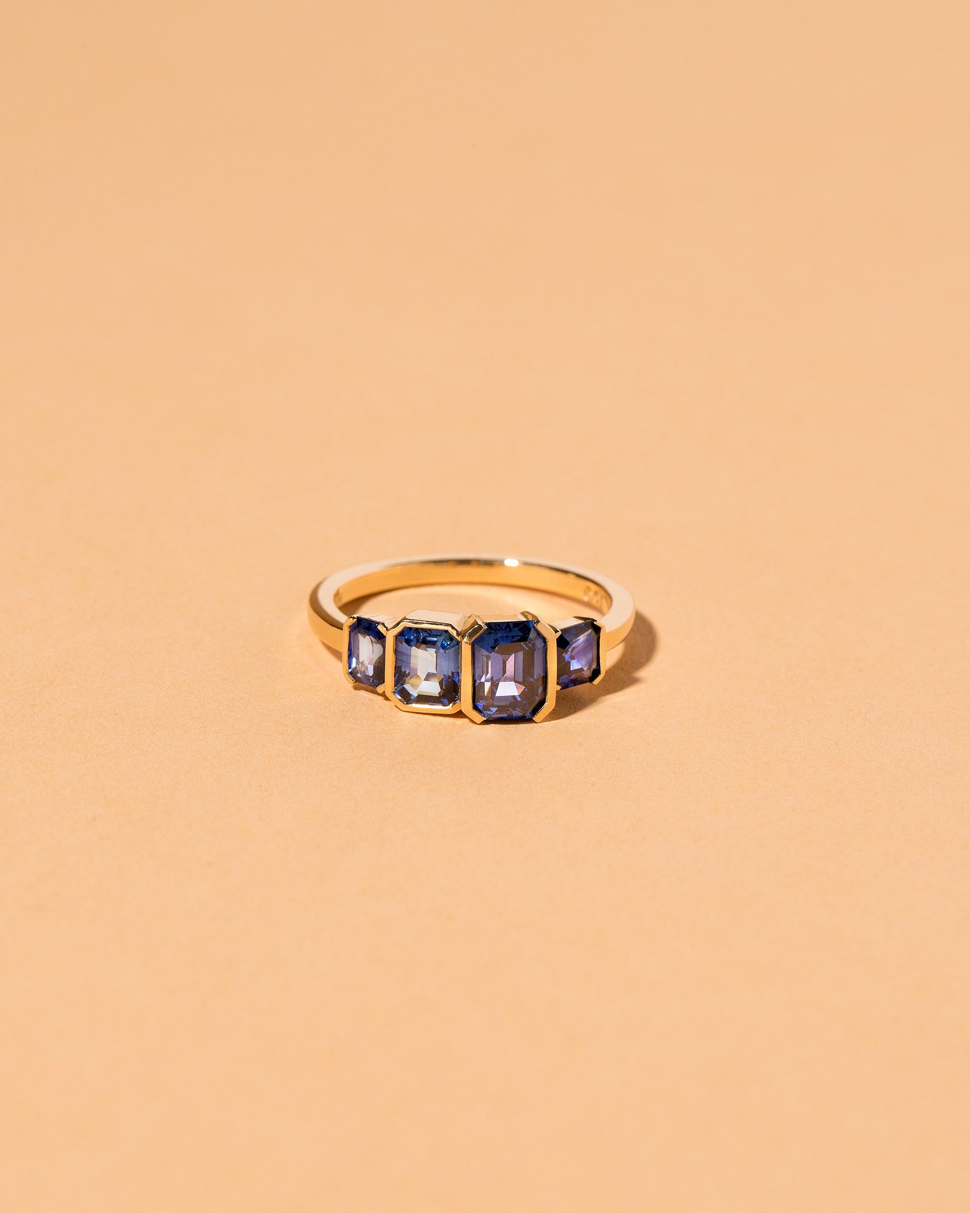 Geometric Sapphire Line Cluster Ring on light color background.