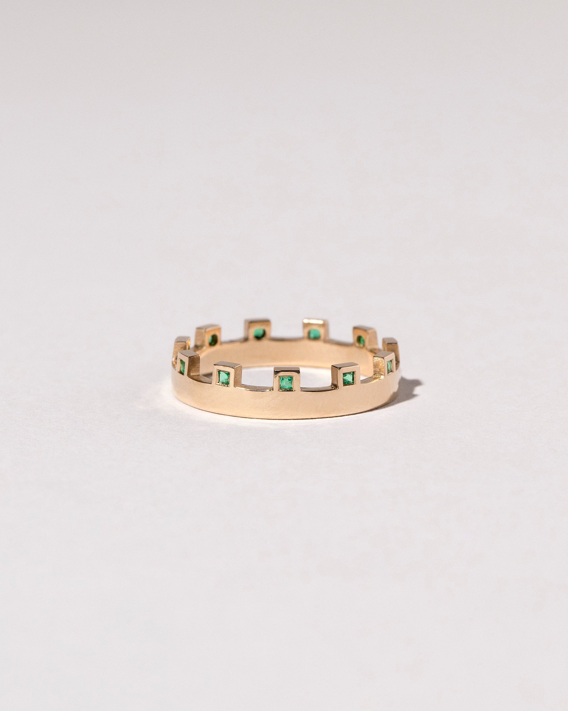 Gold Emerald Connection Band on light color background.