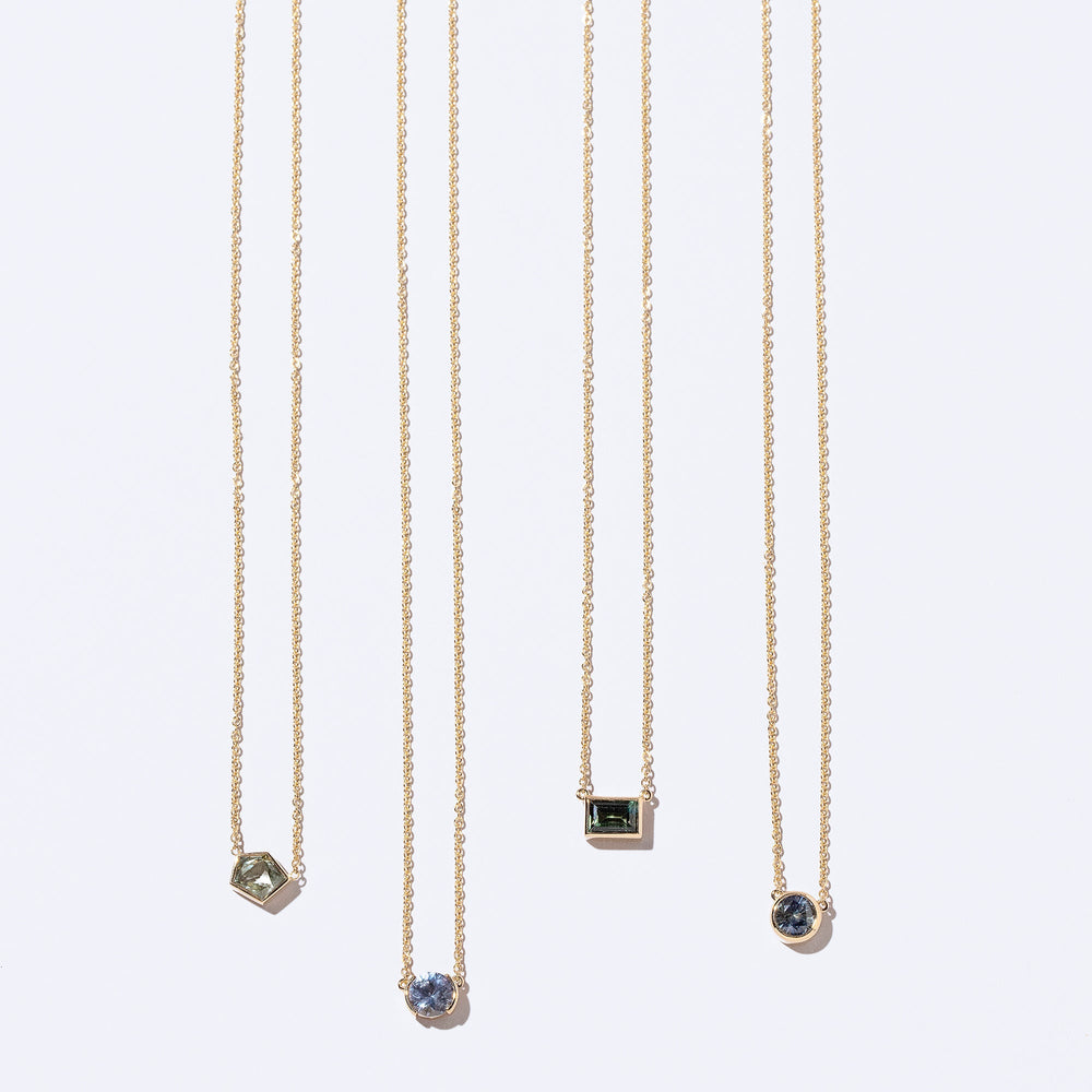 product_details::Geometric Sapphire Necklaces on light colored background.