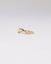 View from the side of the Gold Single Stone Blue Sapphire Curve Band on light color background.