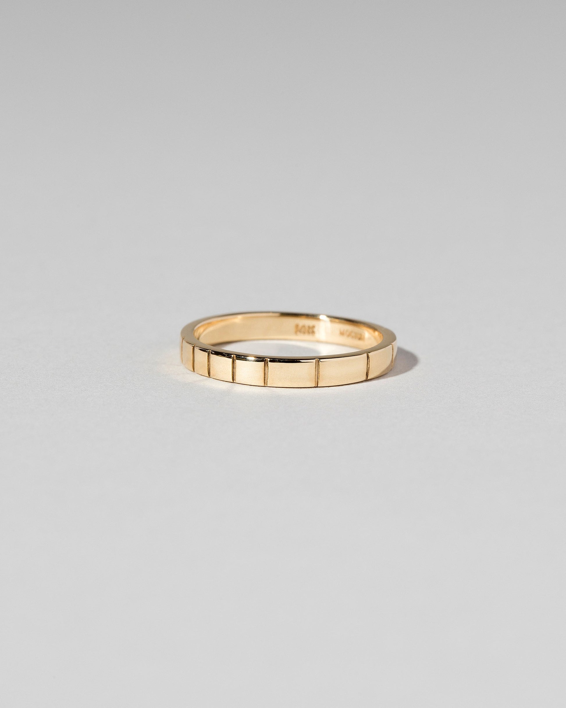 View from the side of the Gold 2mm Etched Lines Bands on light color background.