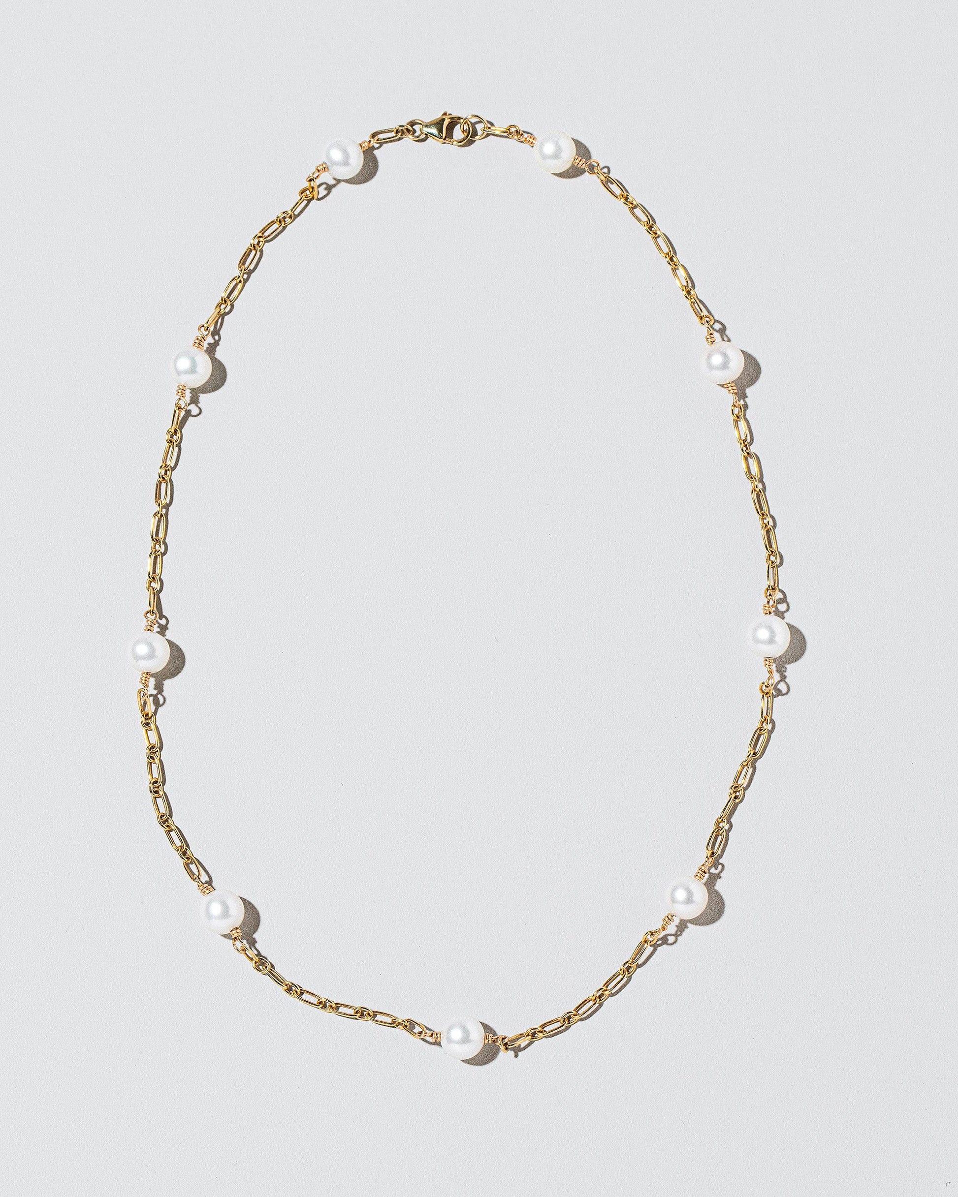  Pearl Station Necklace on light color background.