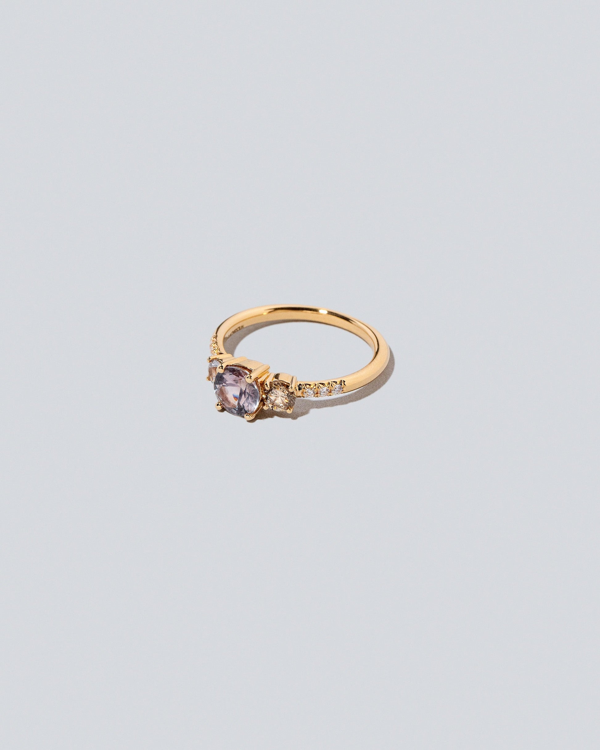View from the side of the Purple Sapphire & Champagne Diamond Orion Ring on light color background.
