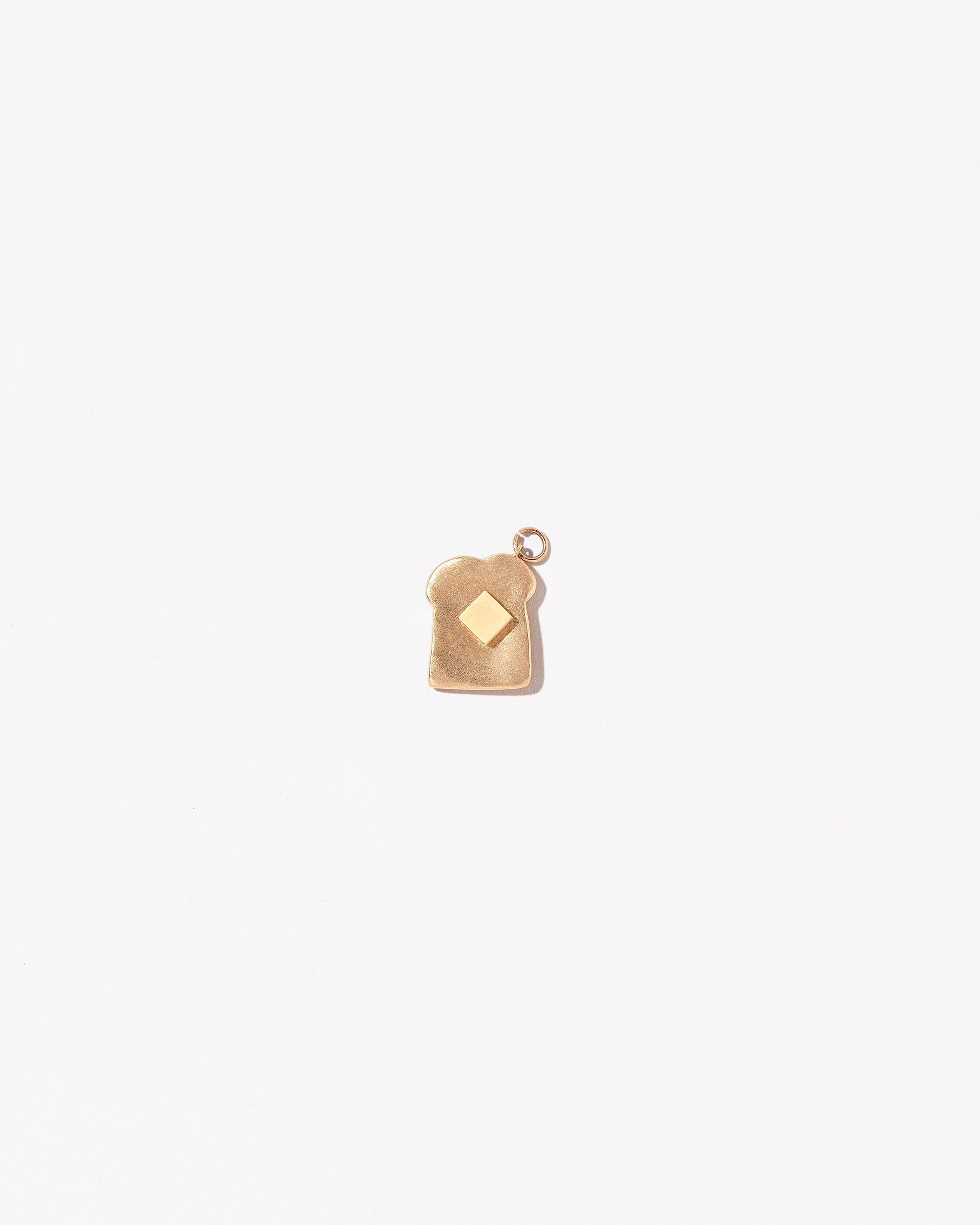 Buttered Toast Charm on light color background.
