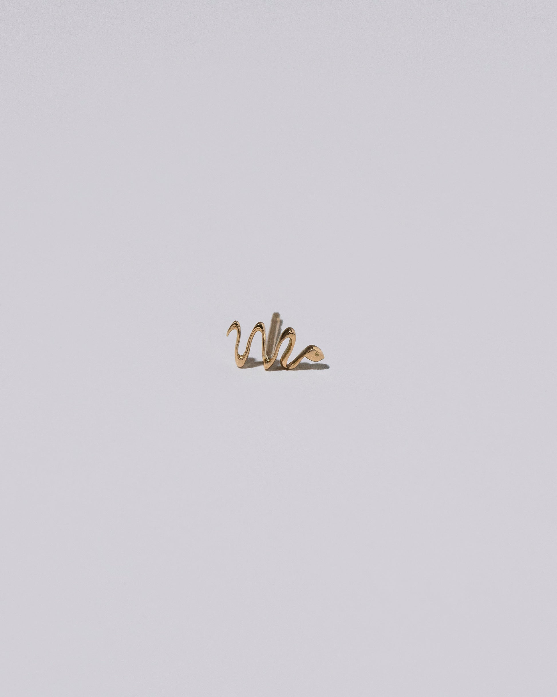 Right Snake Stud Earring Single on light color background.