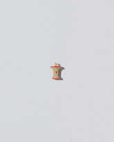 Red Apple Core Charm on light color background.