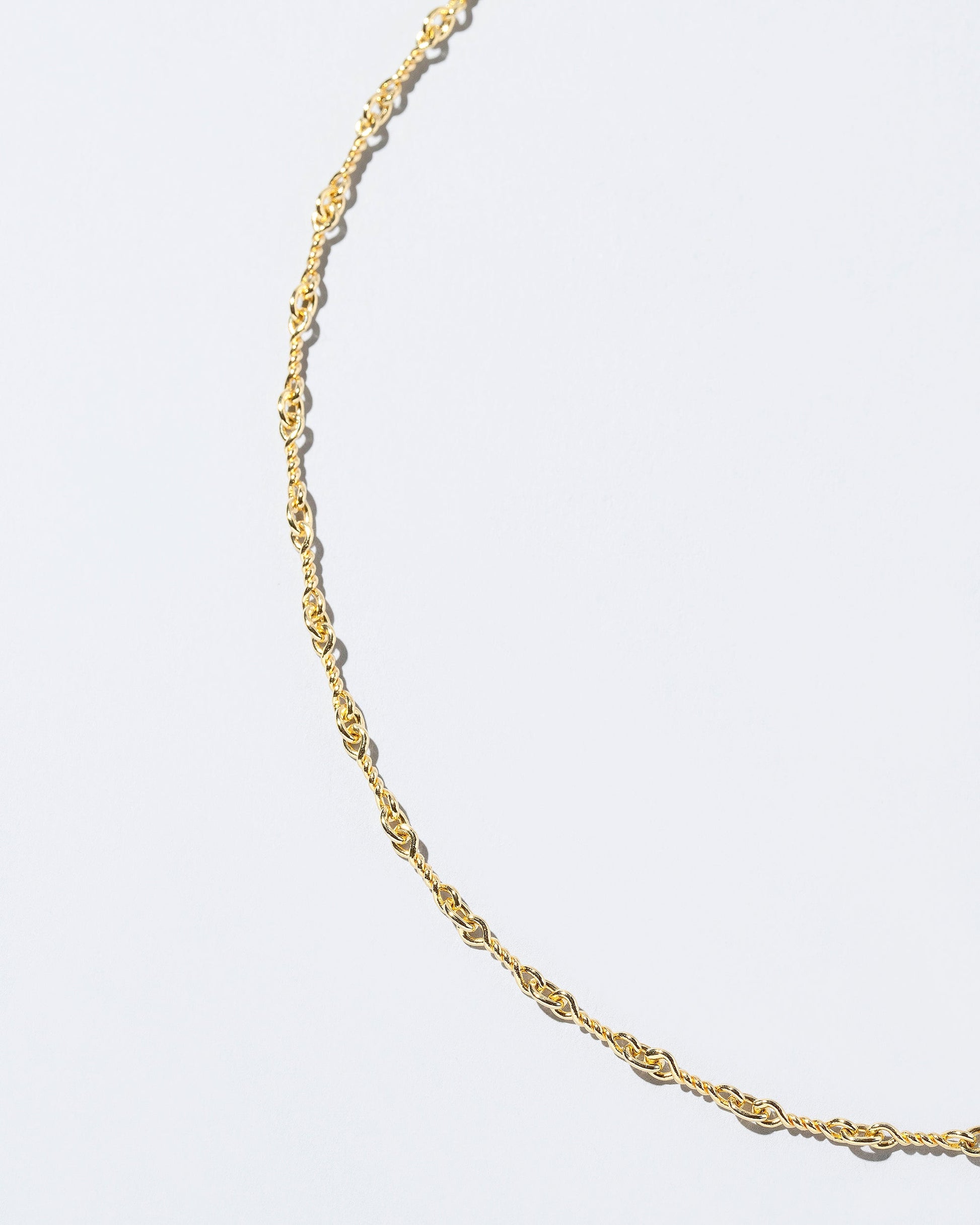 Closeup detail of the Twisted Chain Necklace on light color background.