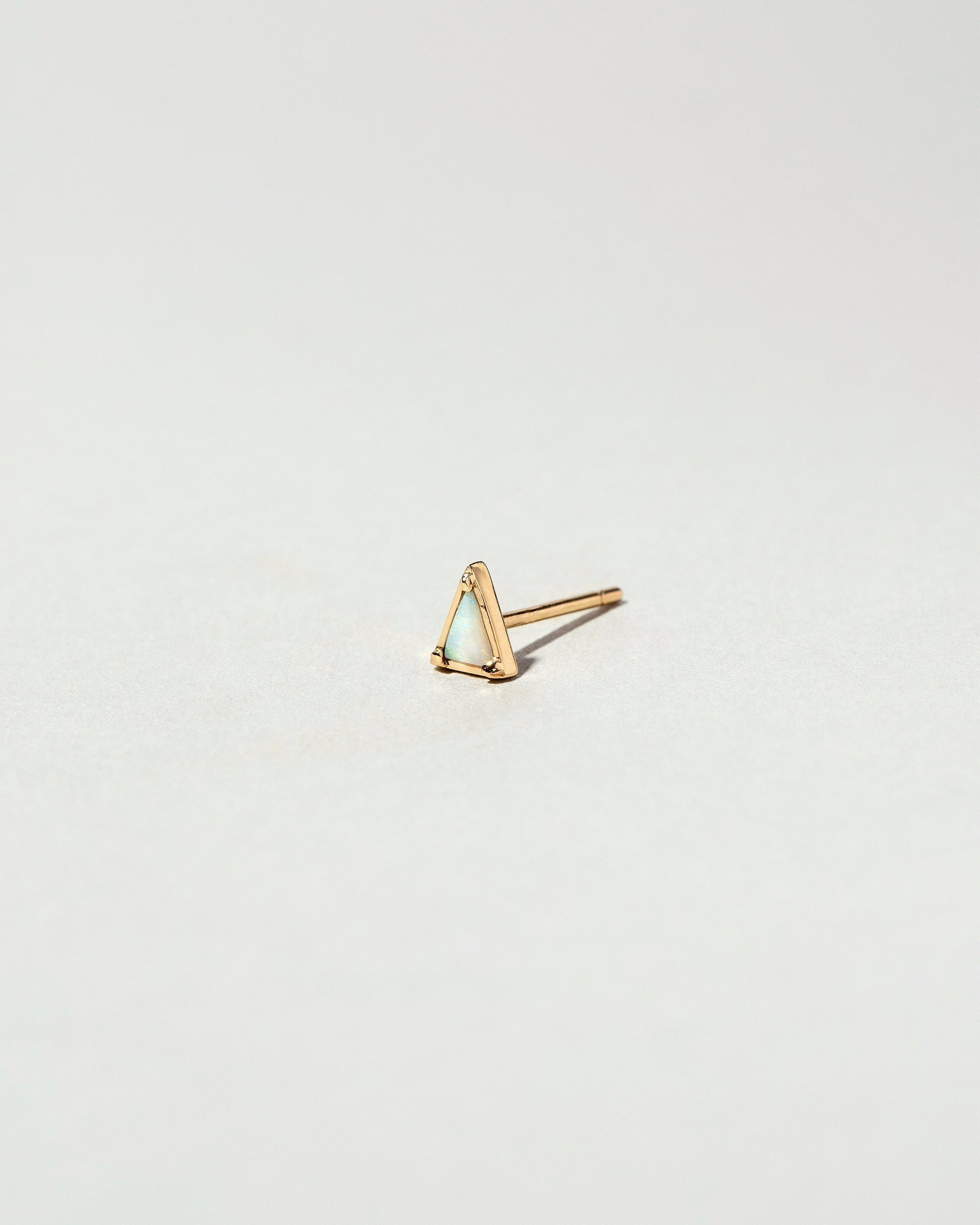 Gold White Opal Triangle Stud Earring Single on light color background.