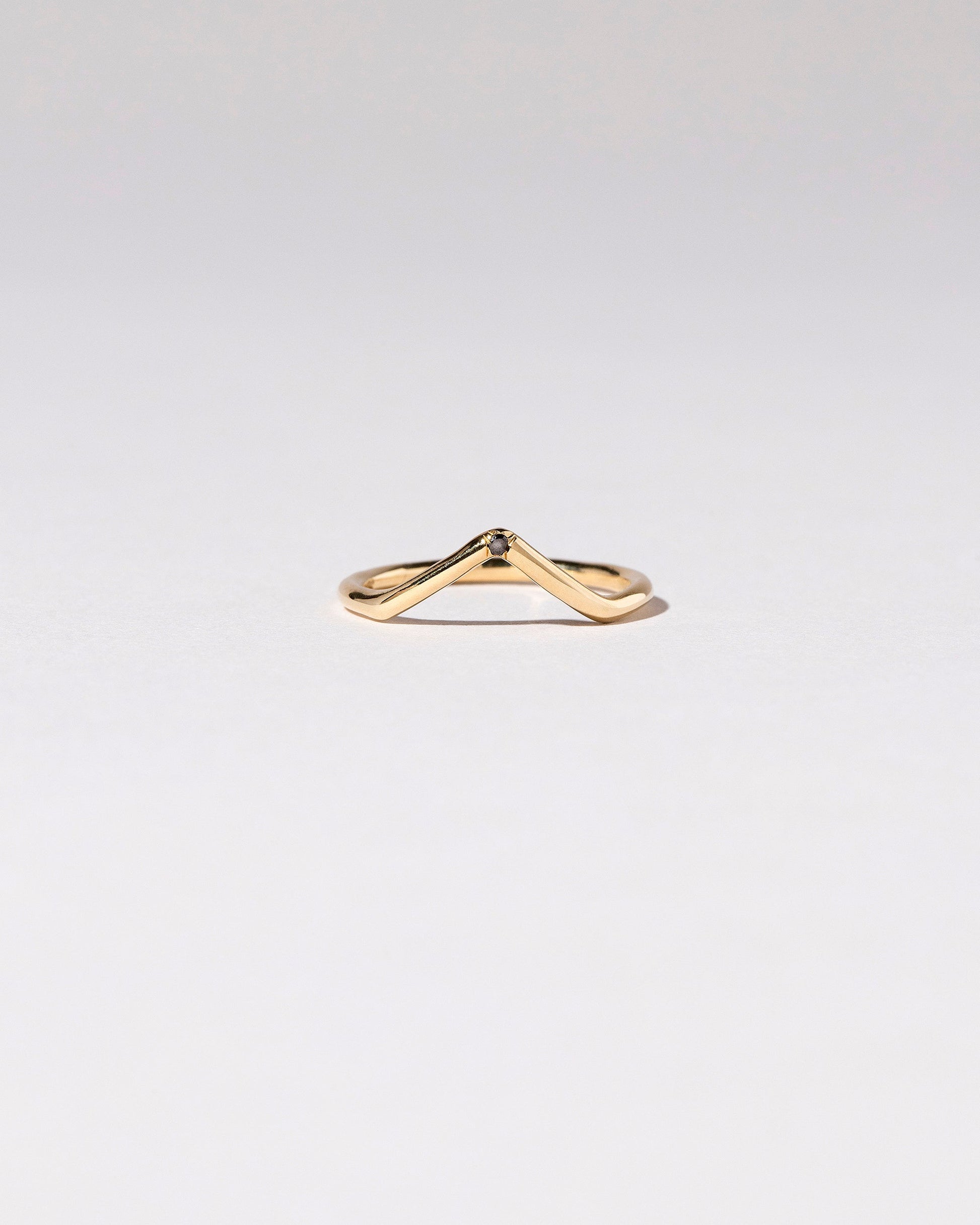 Gold Single Stone Black Diamond High Peak Band on light color background.