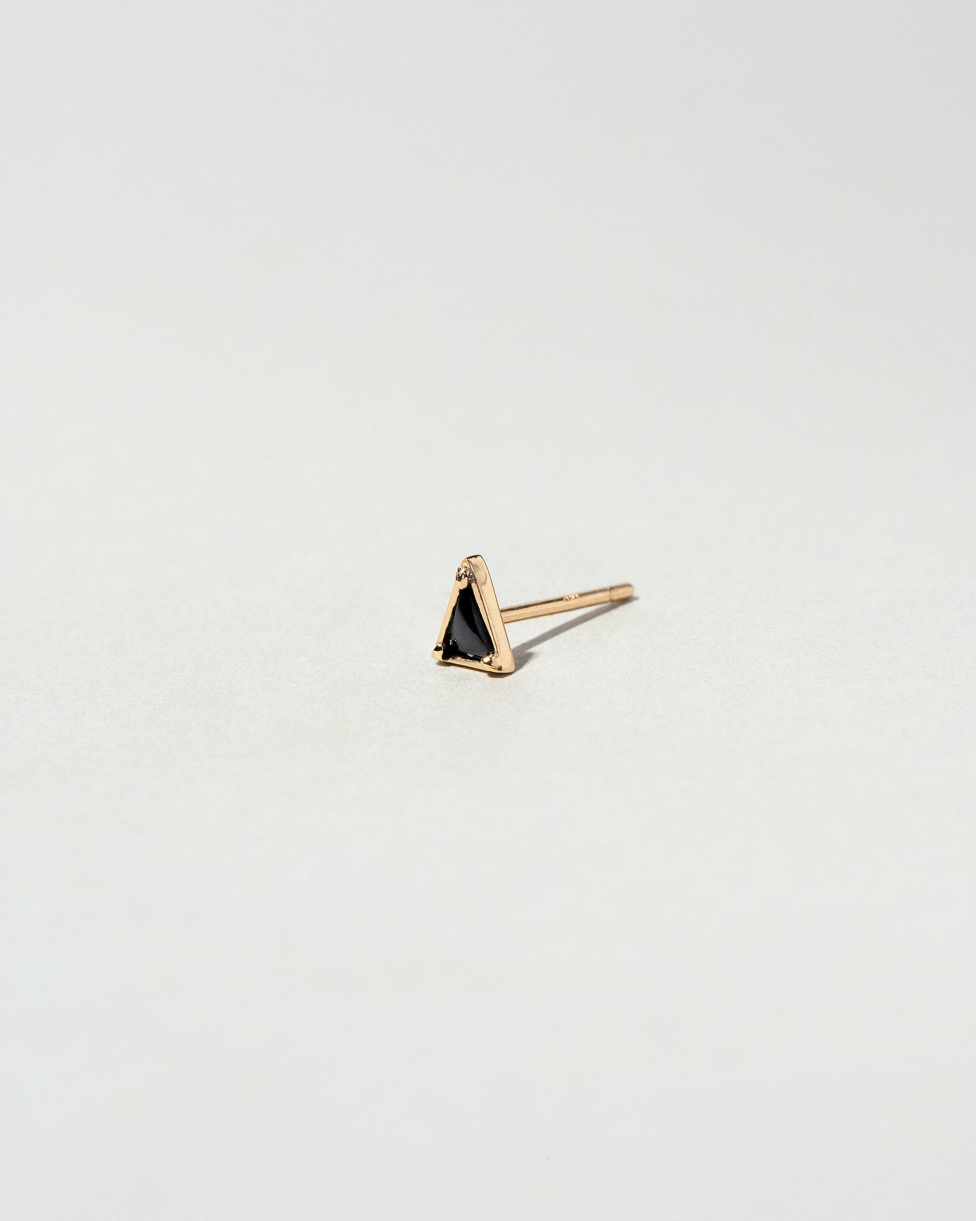 Gold Black Spinel Triangle Stud Earring Single on light color background.