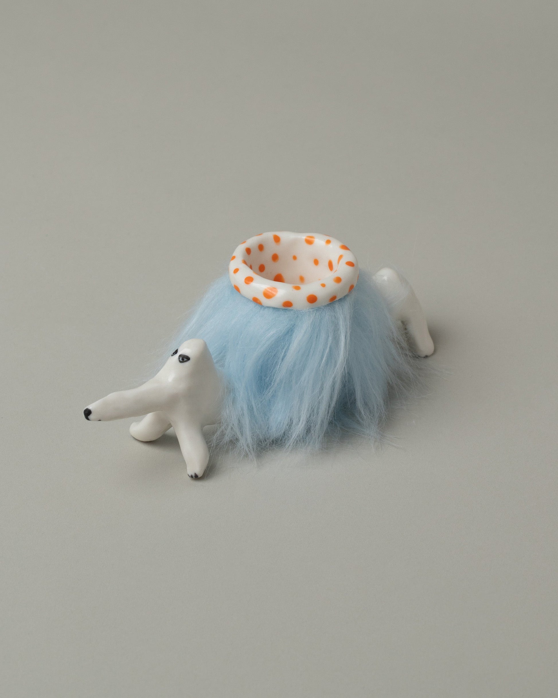 Closeup detail of the Eleonor Boström Orange Furry Baggage Dog on light color background.